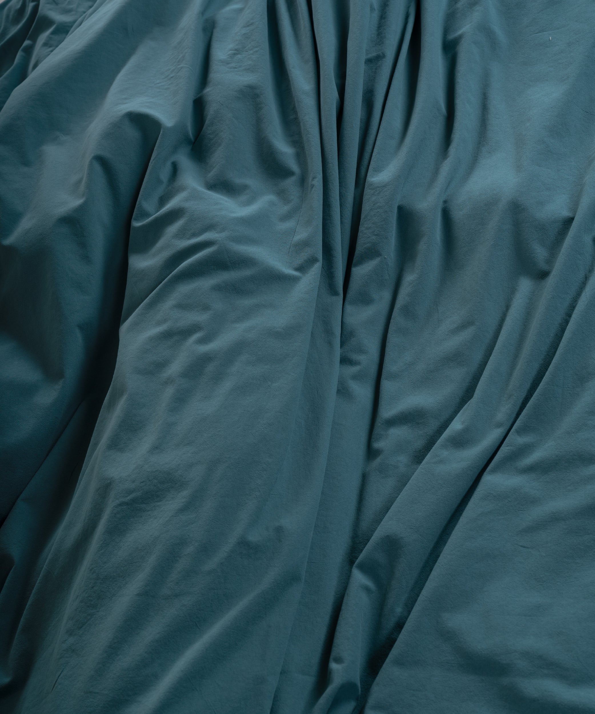 Double-needle stitched edge on dark green stonewashed cotton pillowcase for durability