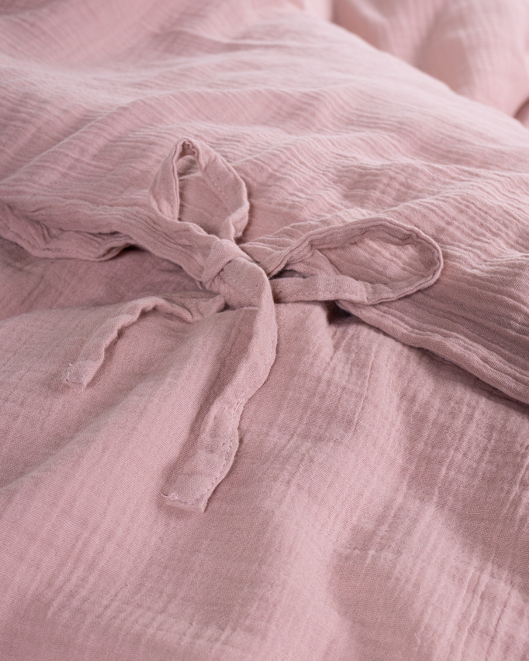 Detail shot of the tie closure on the Esse Old Rose muslin duvet cover showing artisanal fastening – Limasso London