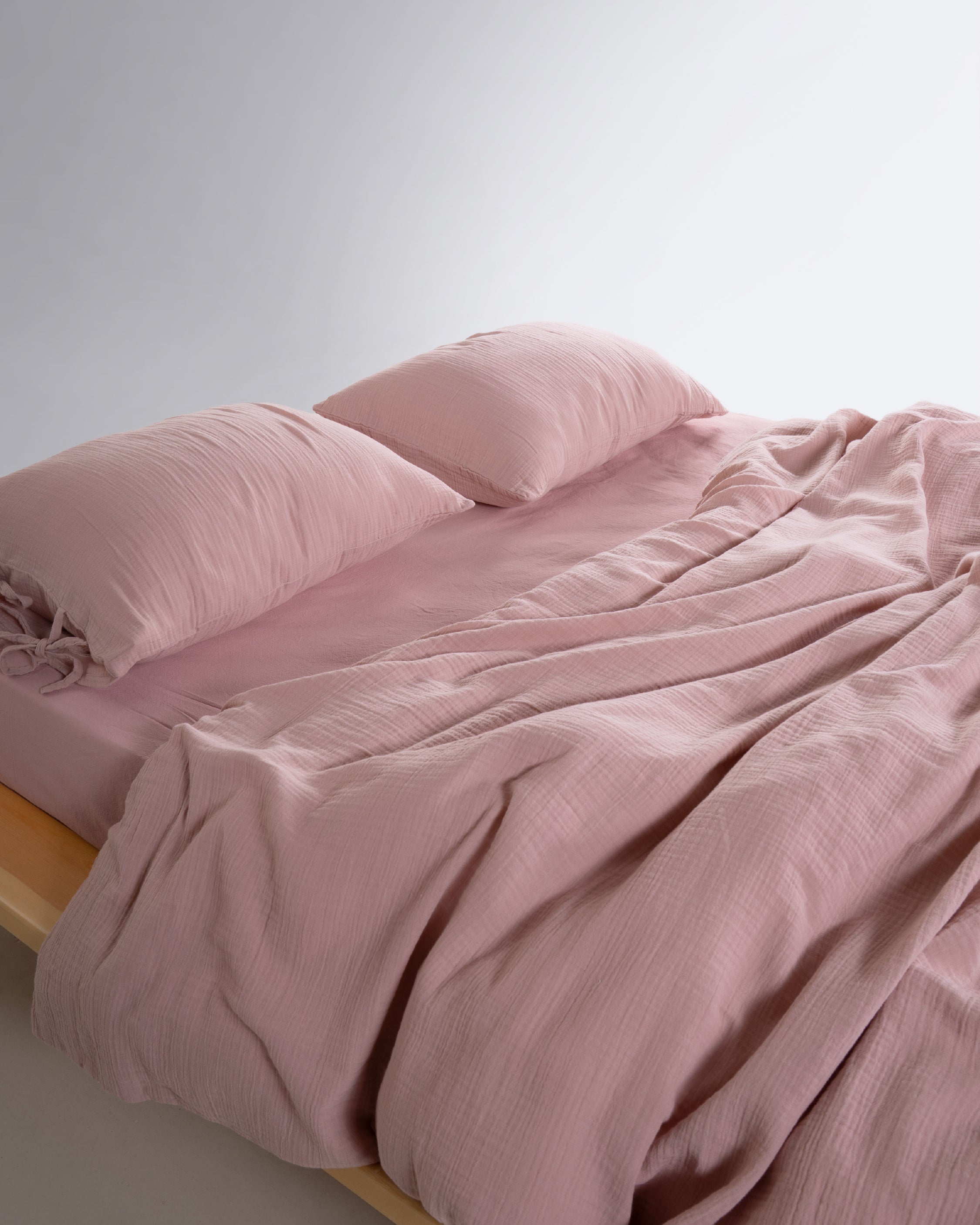 Close-up of Esse Old Rose muslin duvet cover and pillowcase showing cotton gauze weave and colour – Limasso London