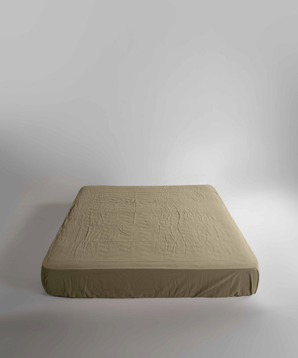 Close-up view of Limasso med green fitted sheet made from 100% stonewashed cotton. Naturally soft, breathable and ideal for everyday luxury bedding in UK homes.