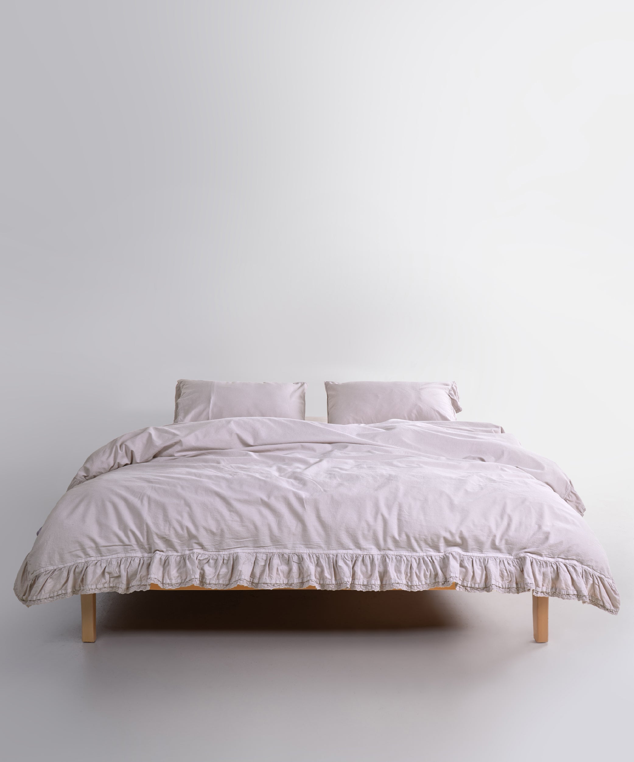 Close up of Sicilia Natura Cream stonewashed cotton duvet cover with elegant ruffle lace trim detail