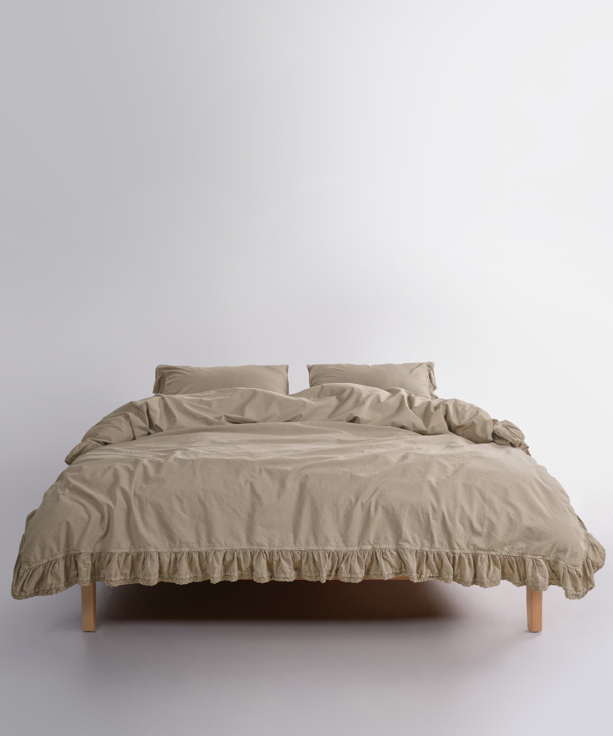 Close up of Sicilia Oxford Tan stonewashed cotton duvet cover with elegant ruffle lace trim detail