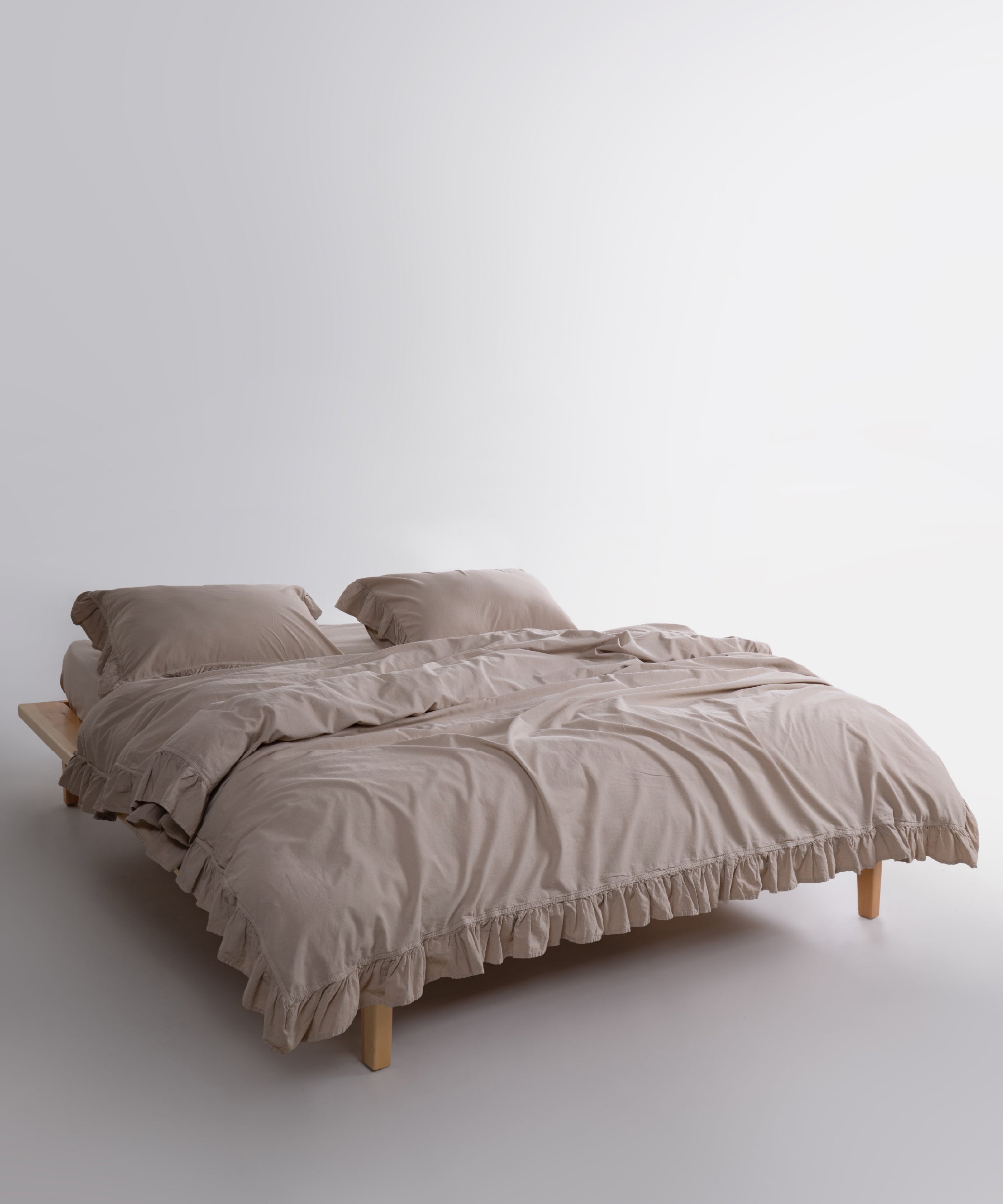 Beige stonewashed cotton duvet cover and pillowcases with ruffled edges styled on a modern UK USA and Canada bed