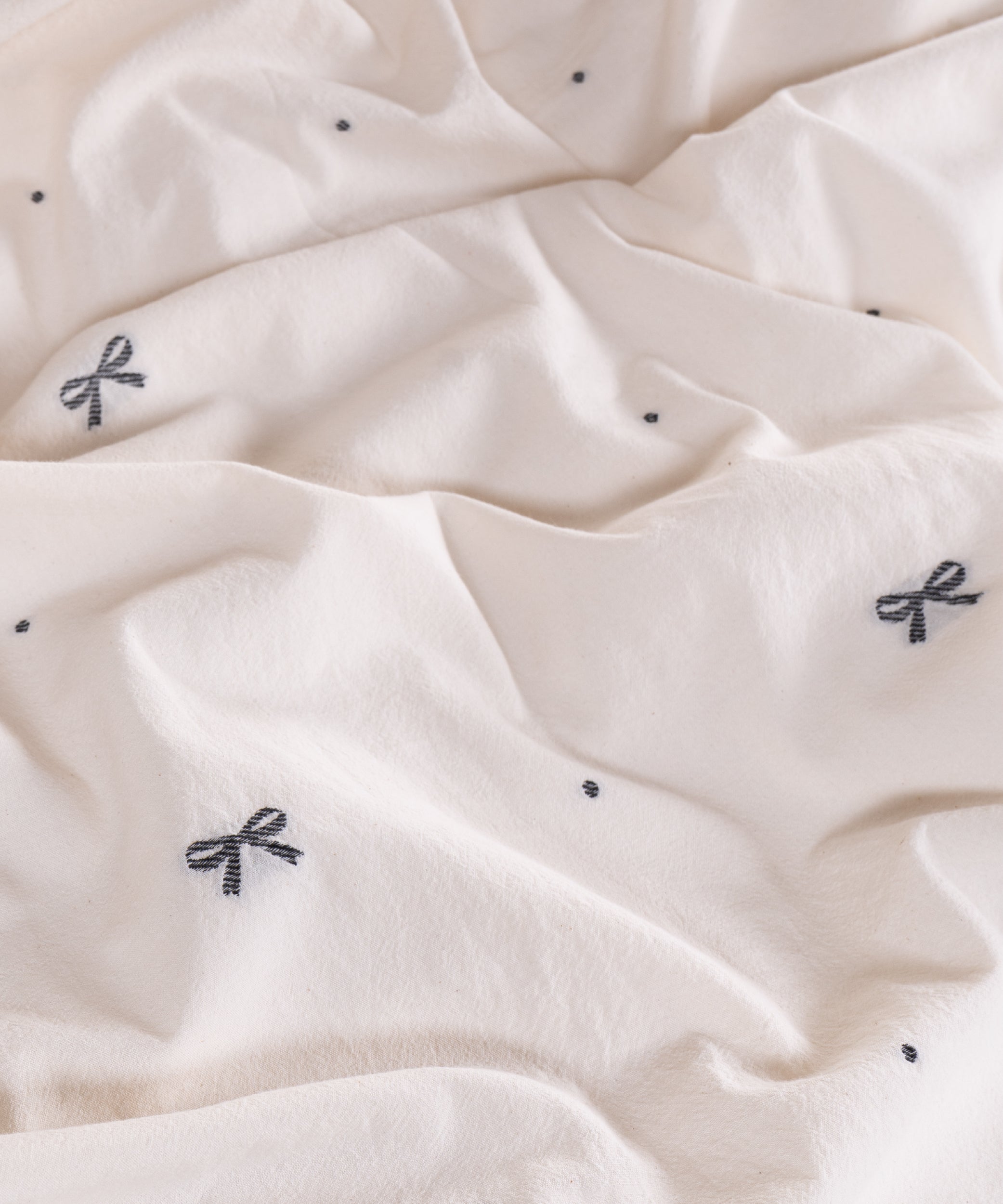 Close-up of garment washed cream cotton fabric with woven jacquard ribbon texture – Limasso London