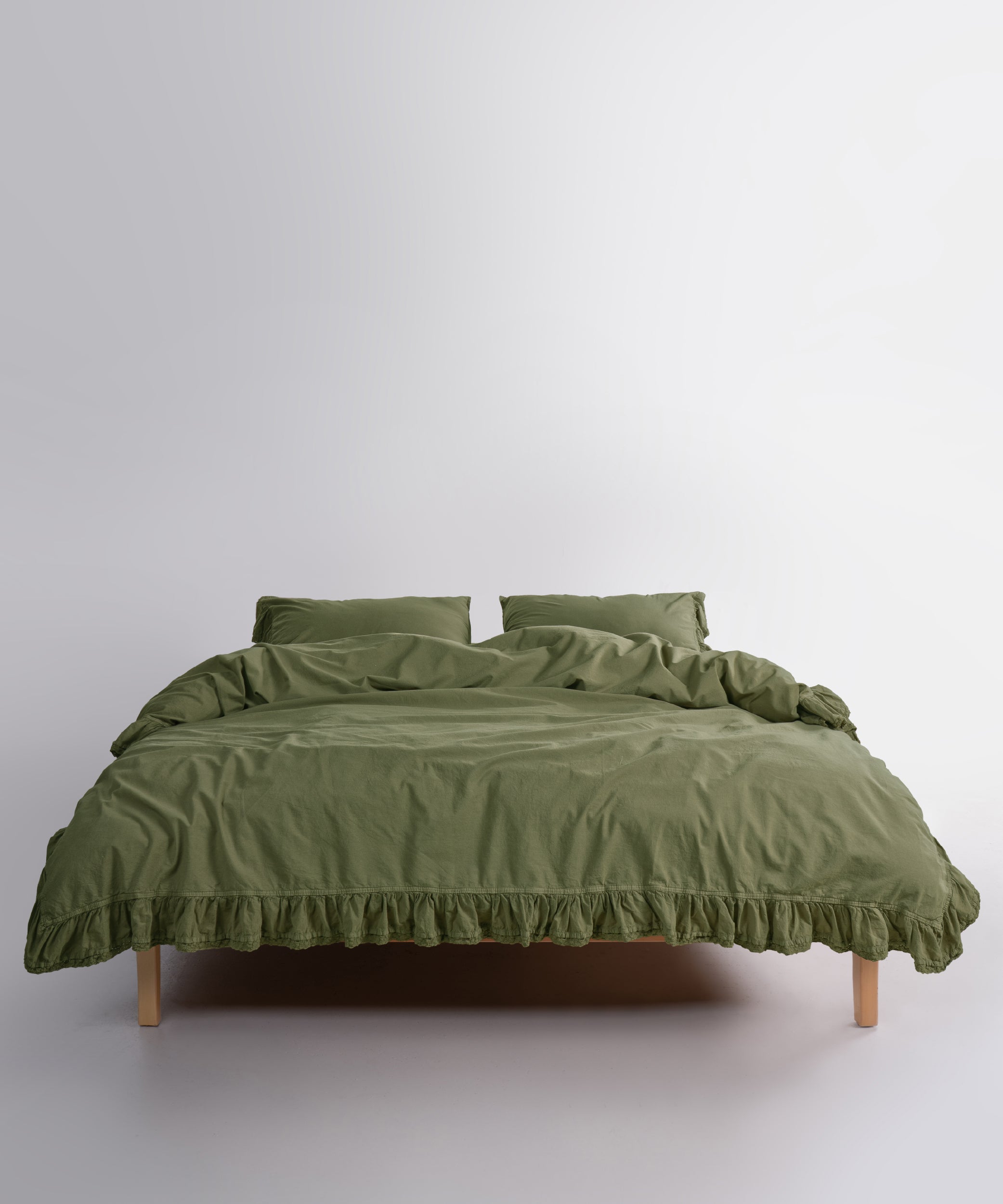 Close up of Sicilia Capulet Olive stonewashed cotton duvet cover with elegant ruffle lace trim detail