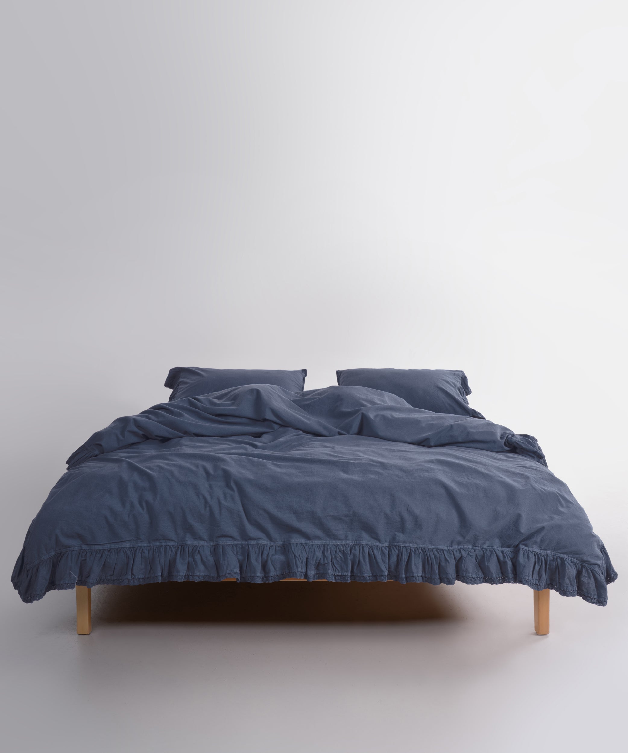 Close up of Sicilia Castle Rock stonewashed cotton duvet cover with elegant ruffle lace trim detail