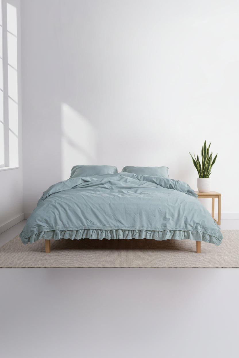 Stonewashed 100% cotton duvet cover set in mint green, styled on a bed with soft ruffled edges. Breathable, relaxed and naturally elegant bedding for a calm bedroom.