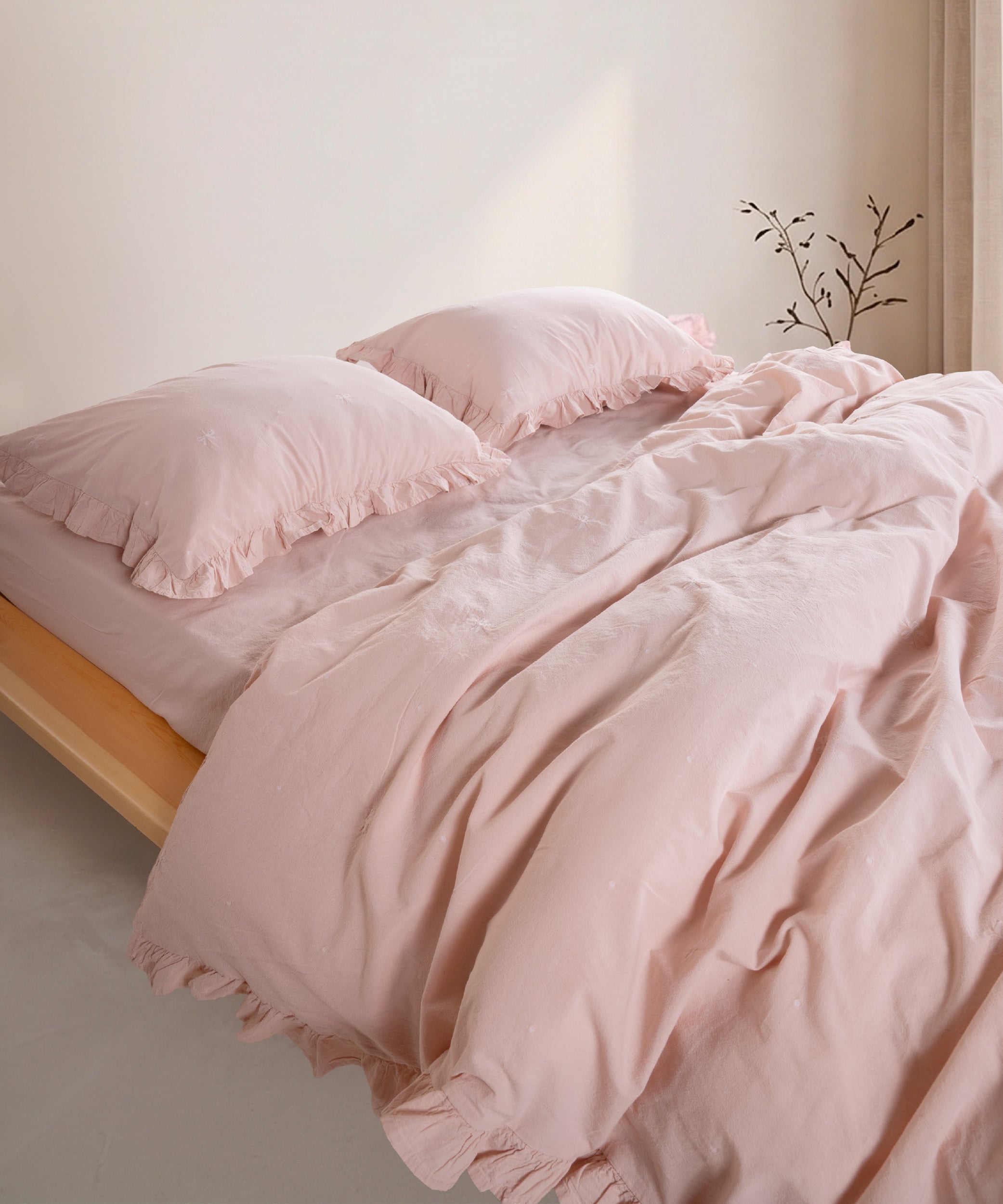 Pristine stonewashed 100% cotton duvet cover set with ruffled edges styled on modern UK bed