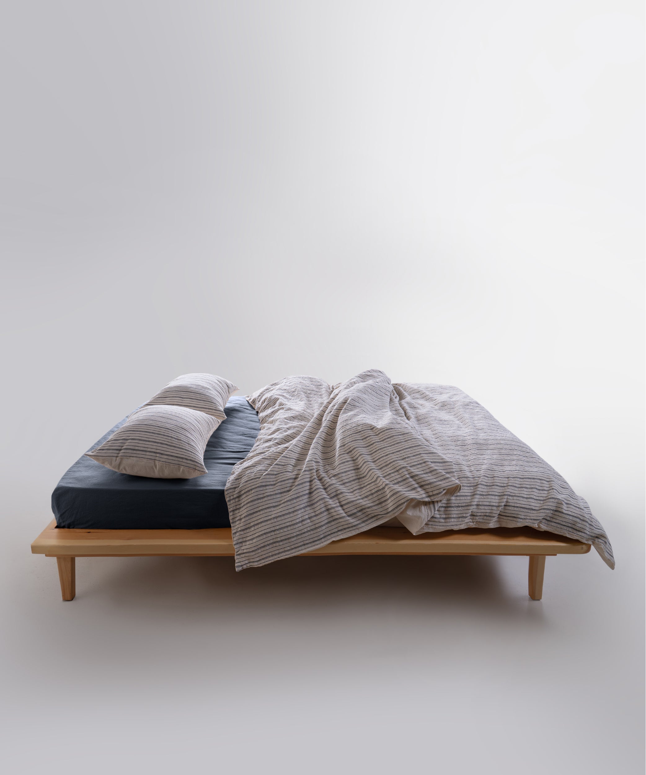Natural cream cotton duvet cover set with navy dotted stripes styled on a double bed