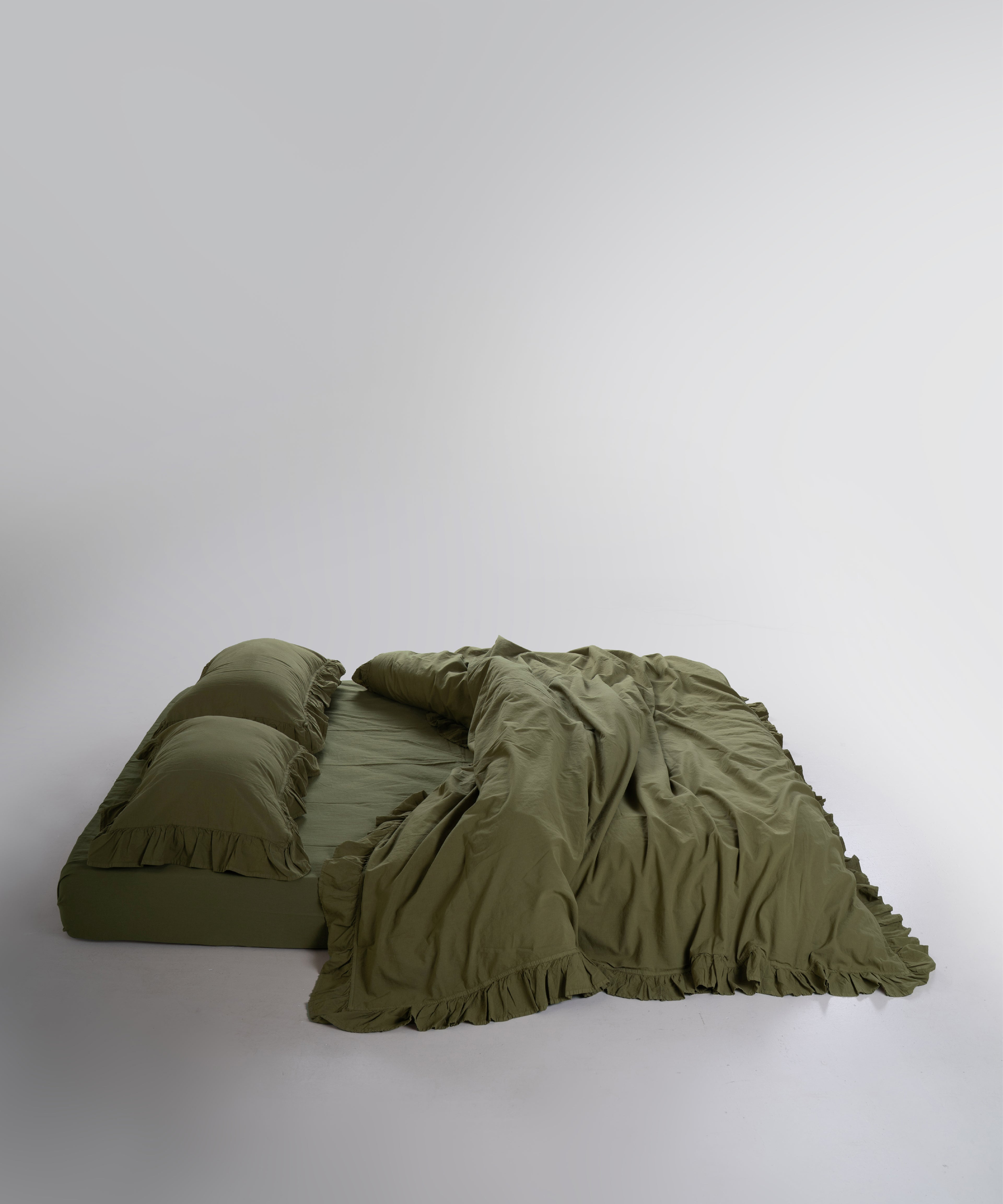 Stonewashed 100% cotton duvet cover set in Capulet Olive by Limasso London with ruffle detailing