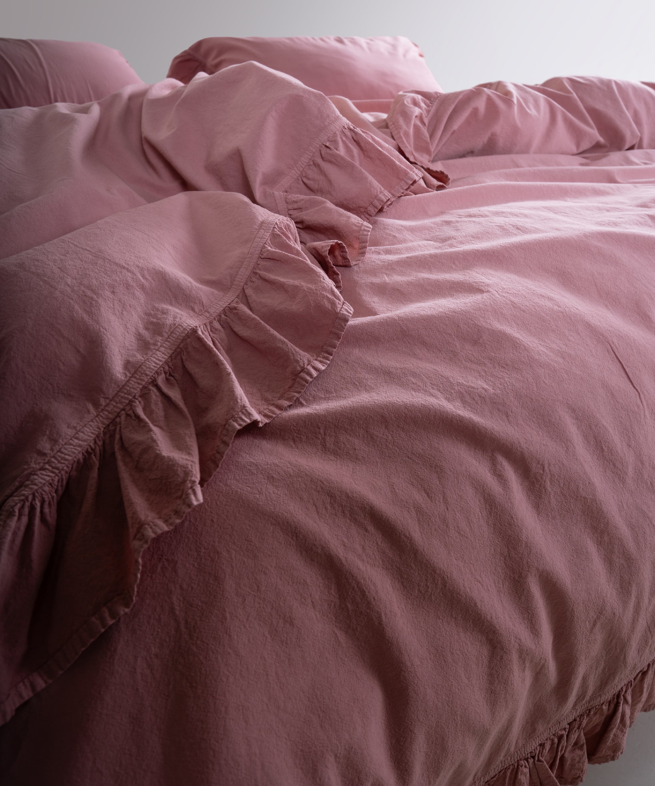 Lifestyle image of stonewashed old rose cotton duvet cover set in a calm and elegant bedroom setting