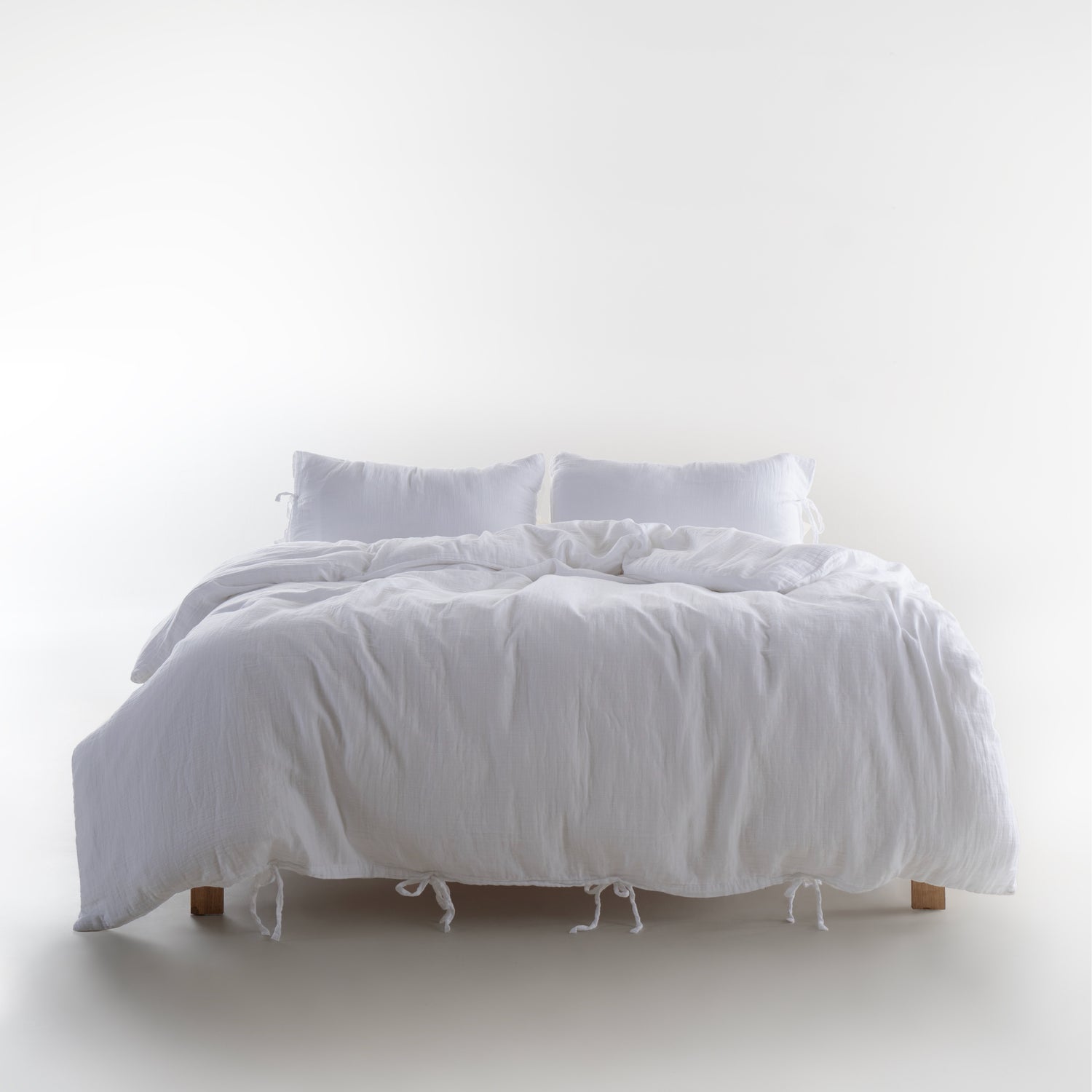 Esse 100% Natural Cotton Gauze-Muslin Duvet Cover Set Snow White on a wooden bed with tie-closure pillowcases – Limasso