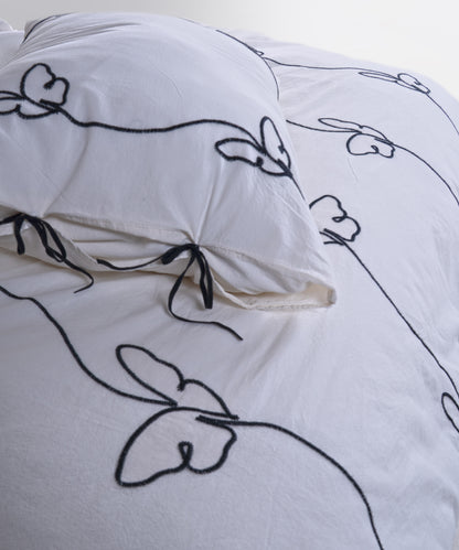 Close-up of the butterfly embroidery on the Snow White stonewashed cotton duvet cover set, showing the delicate stitched detail.