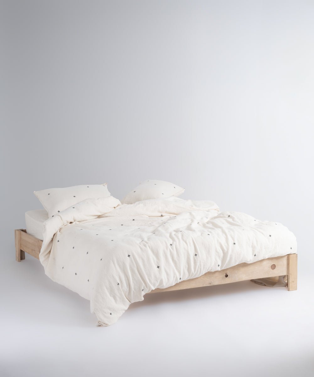 Minimal Scandinavian bedroom styled with cream cotton duvet cover set and black cross pattern design