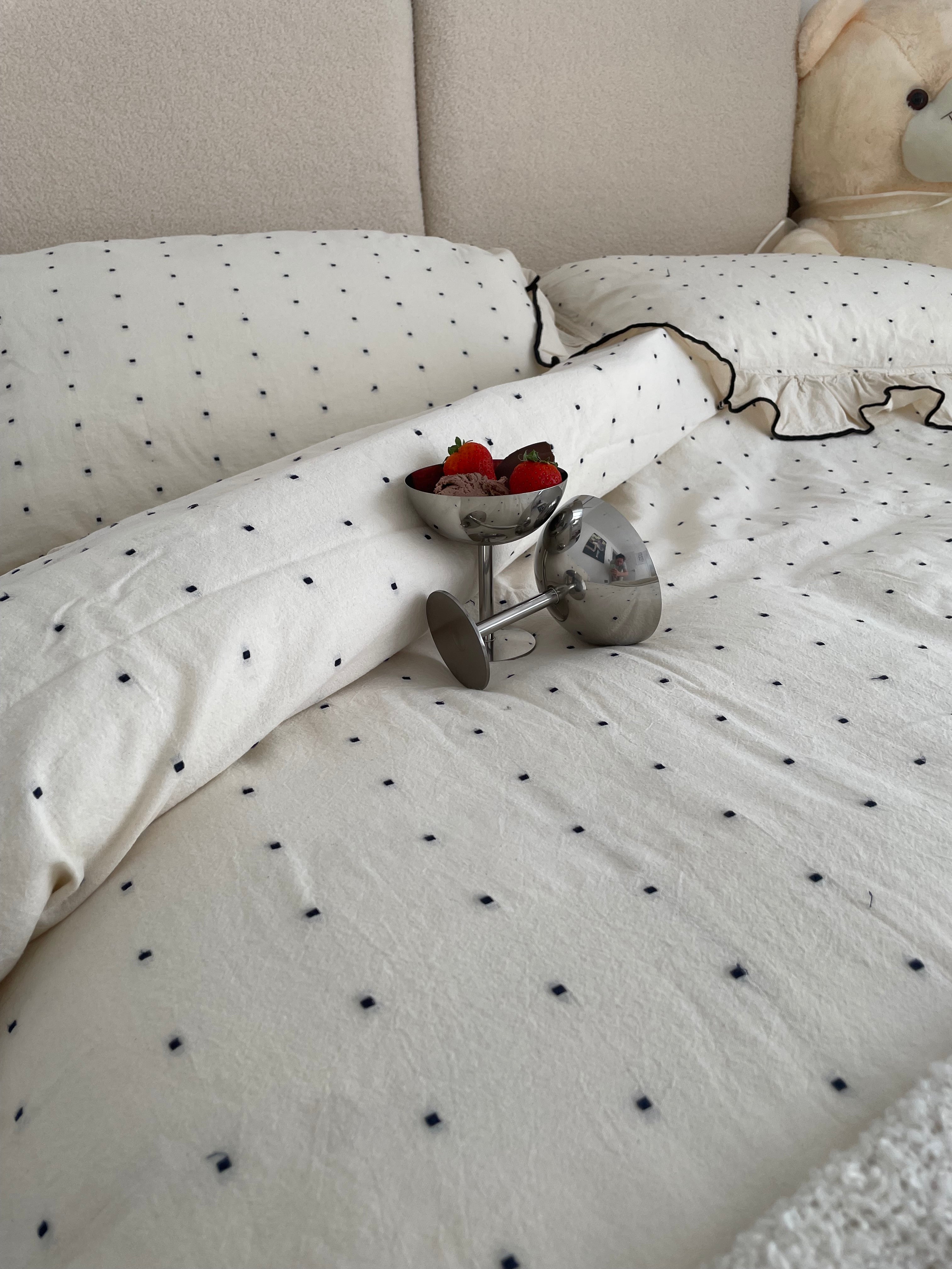Customer photo of Limasso London ruffled garment-washed cotton duvet cover set styled on a bed – natural cream with black dot detail

