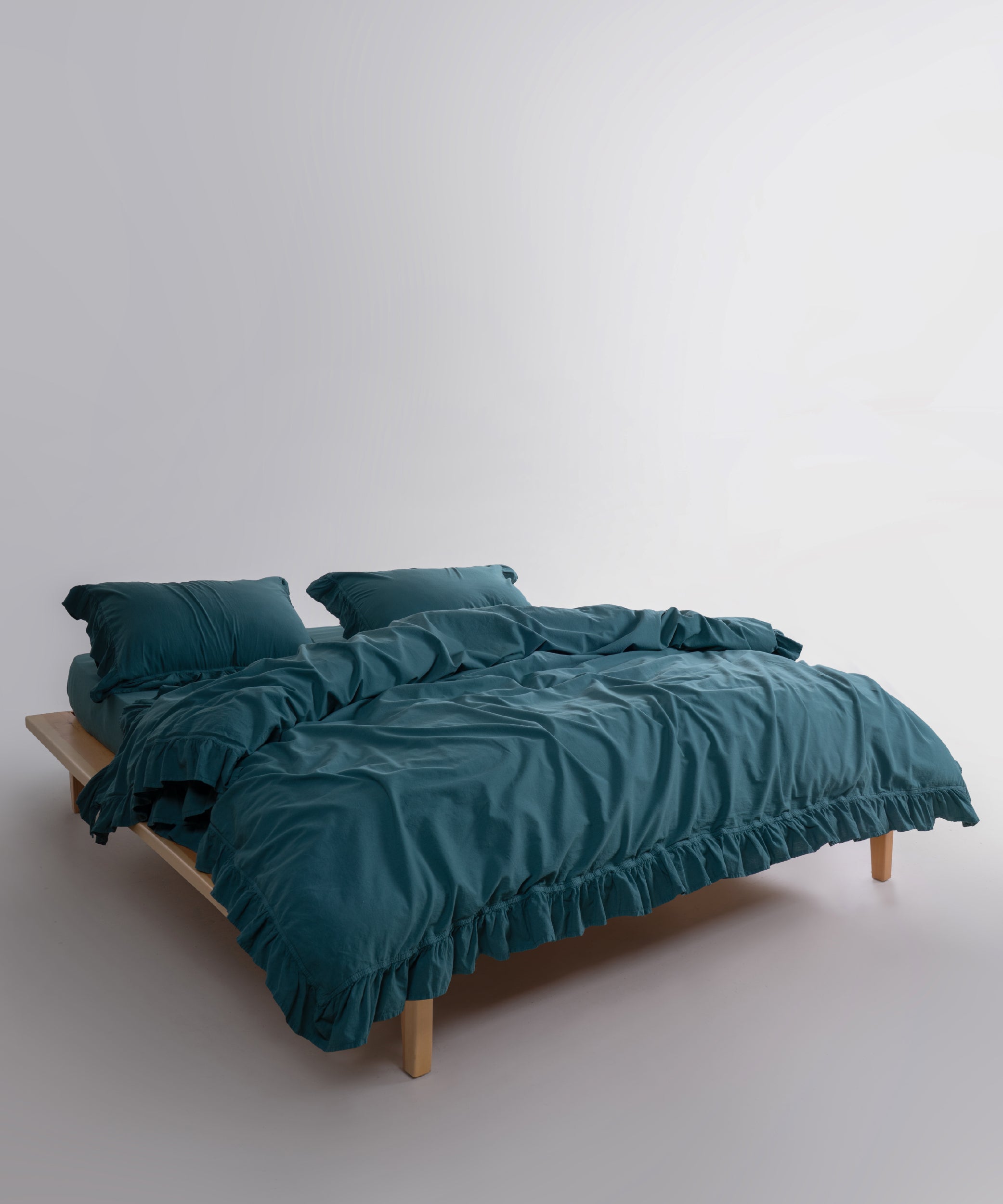 Dark green stonewashed cotton bedding set styled in a modern UK bedroom interior