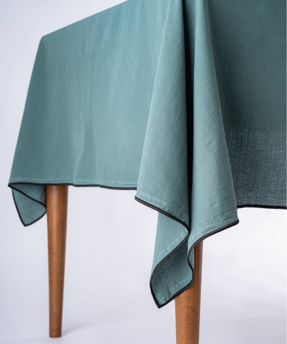 Rectangular dark green cotton tablecloth styled on dining table with plates and decor, embroidered edge kitchen and dining room table cover