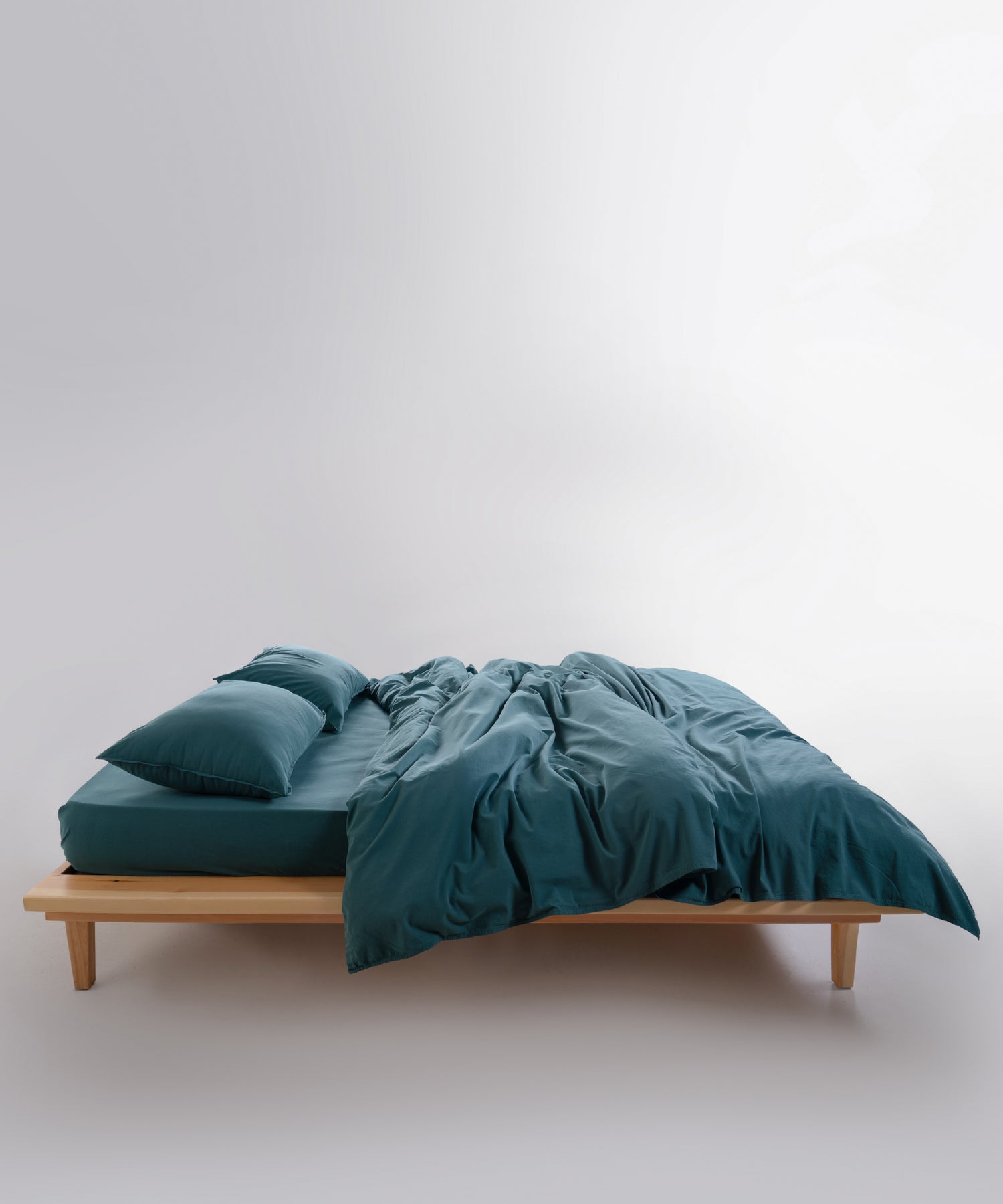Dark green stonewashed cotton pillowcase with smooth finish and minimalist design