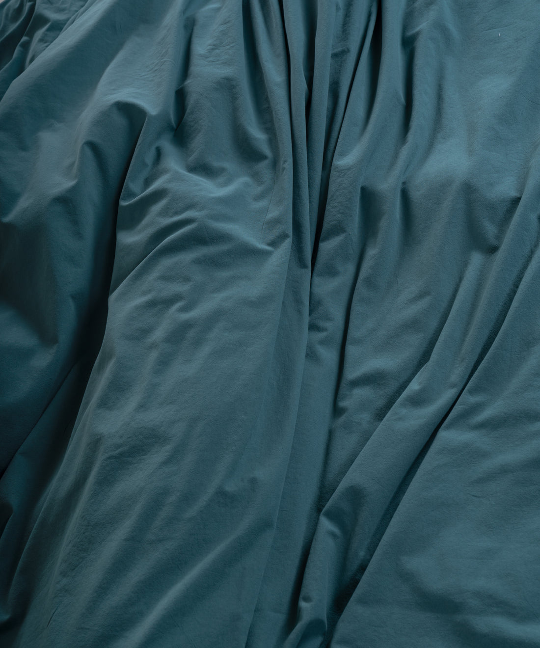 Double-needle stitched edge on dark green stonewashed cotton pillowcase for durability