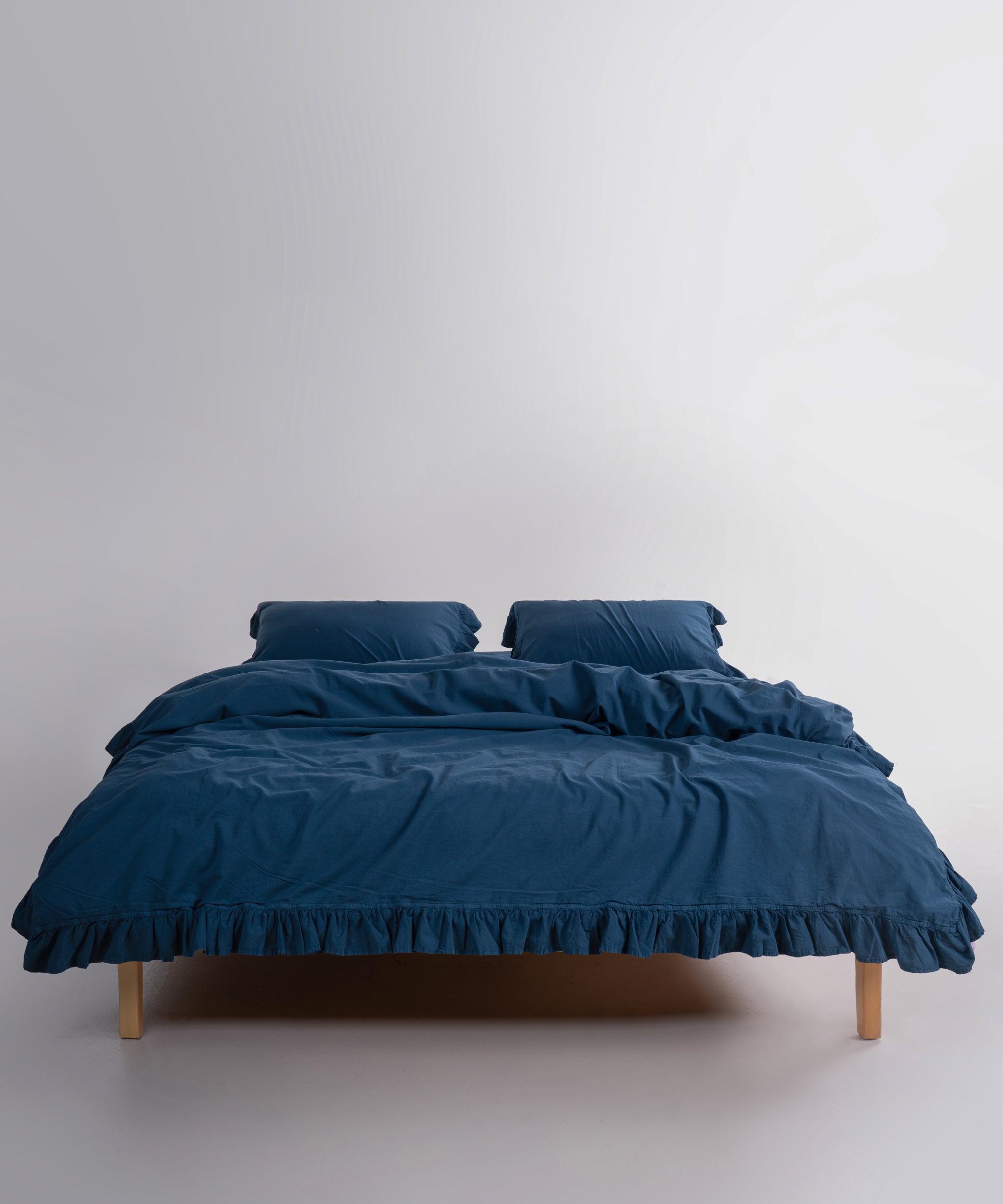 Dress blue stonewashed cotton duvet cover set displayed on bed with relaxed texture and premium British bedroom style