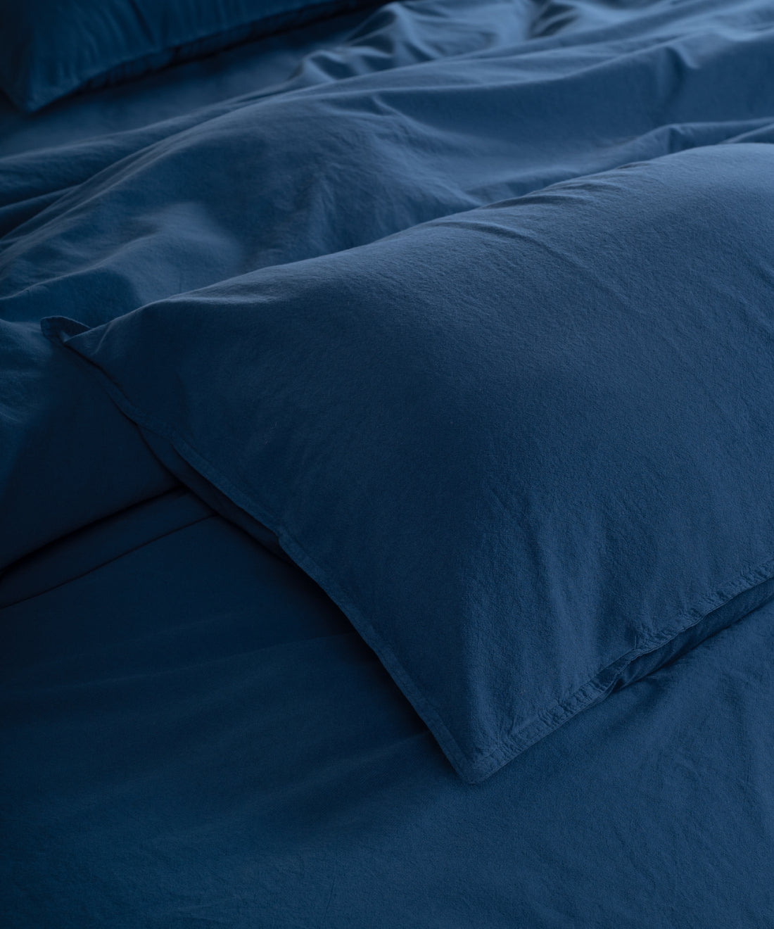 Dress blue stonewashed cotton duvet cover set displayed on bed with relaxed texture and timeless British bedroom style