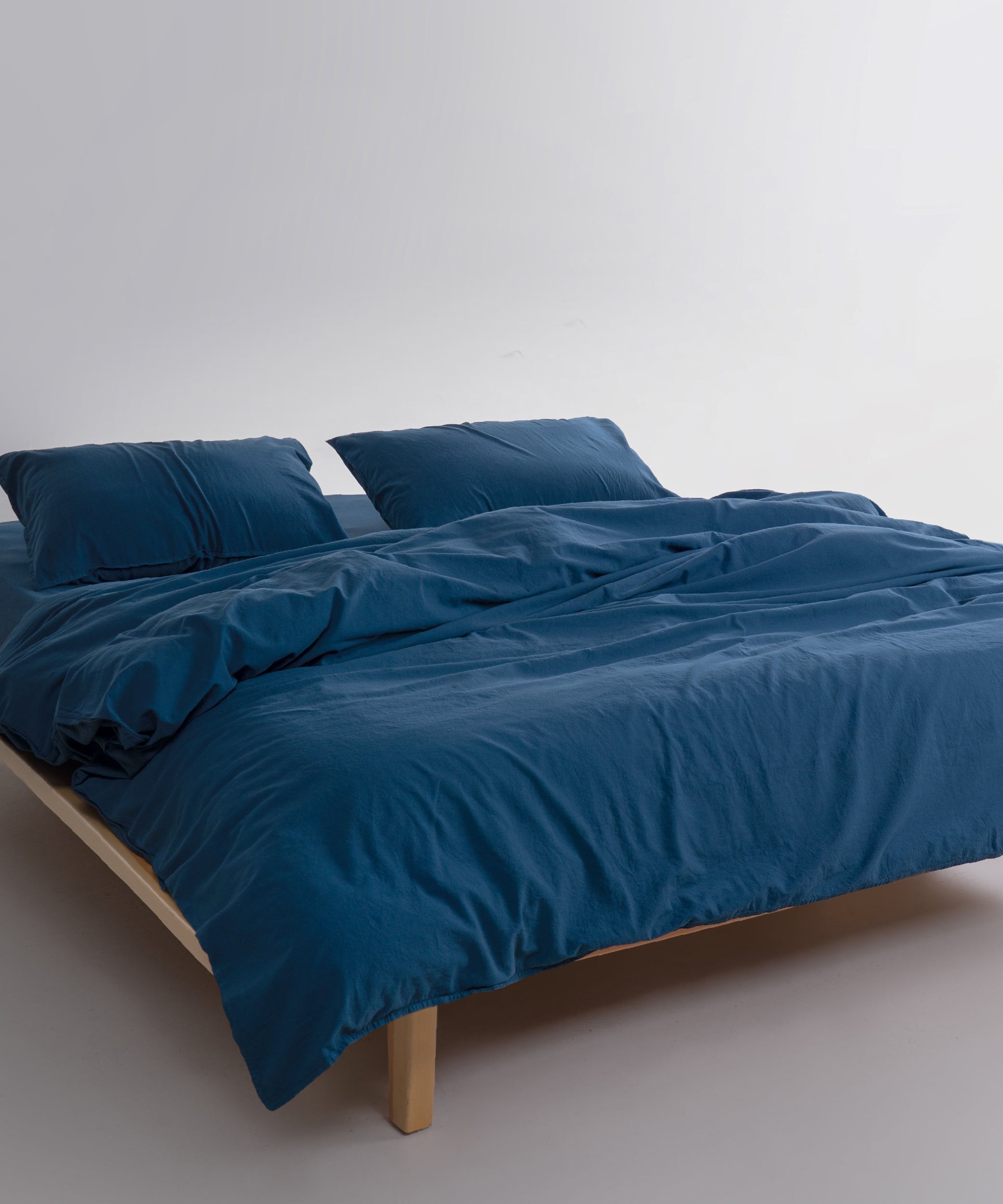 Stonewashed cotton pillowcases in dress blue with soft finish, designed to match duvet cover set