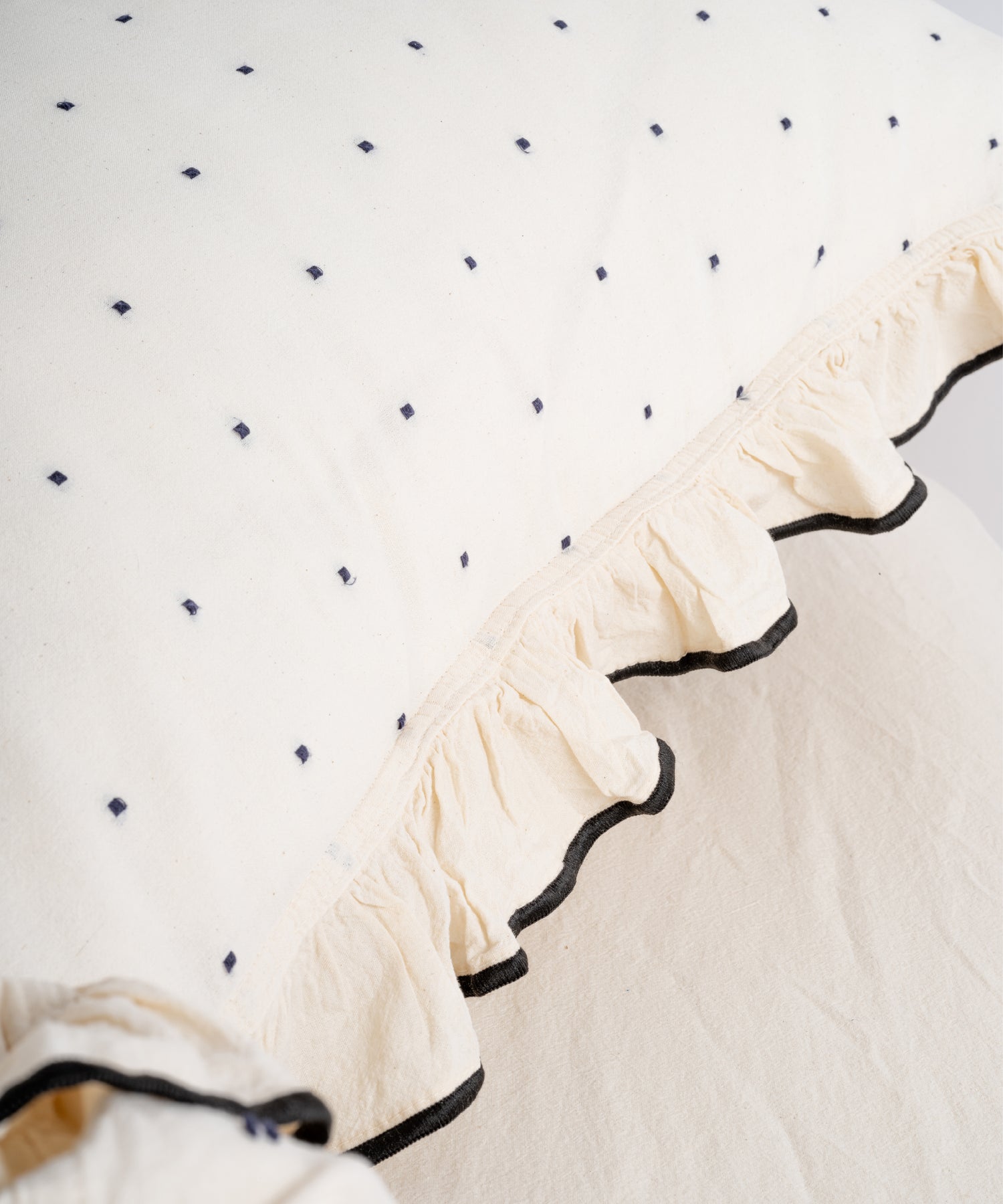 Close-up of embroidered black ruffle trim on Limasso London garment-washed cotton duvet cover – soft texture, black micro-dot fabric detail
