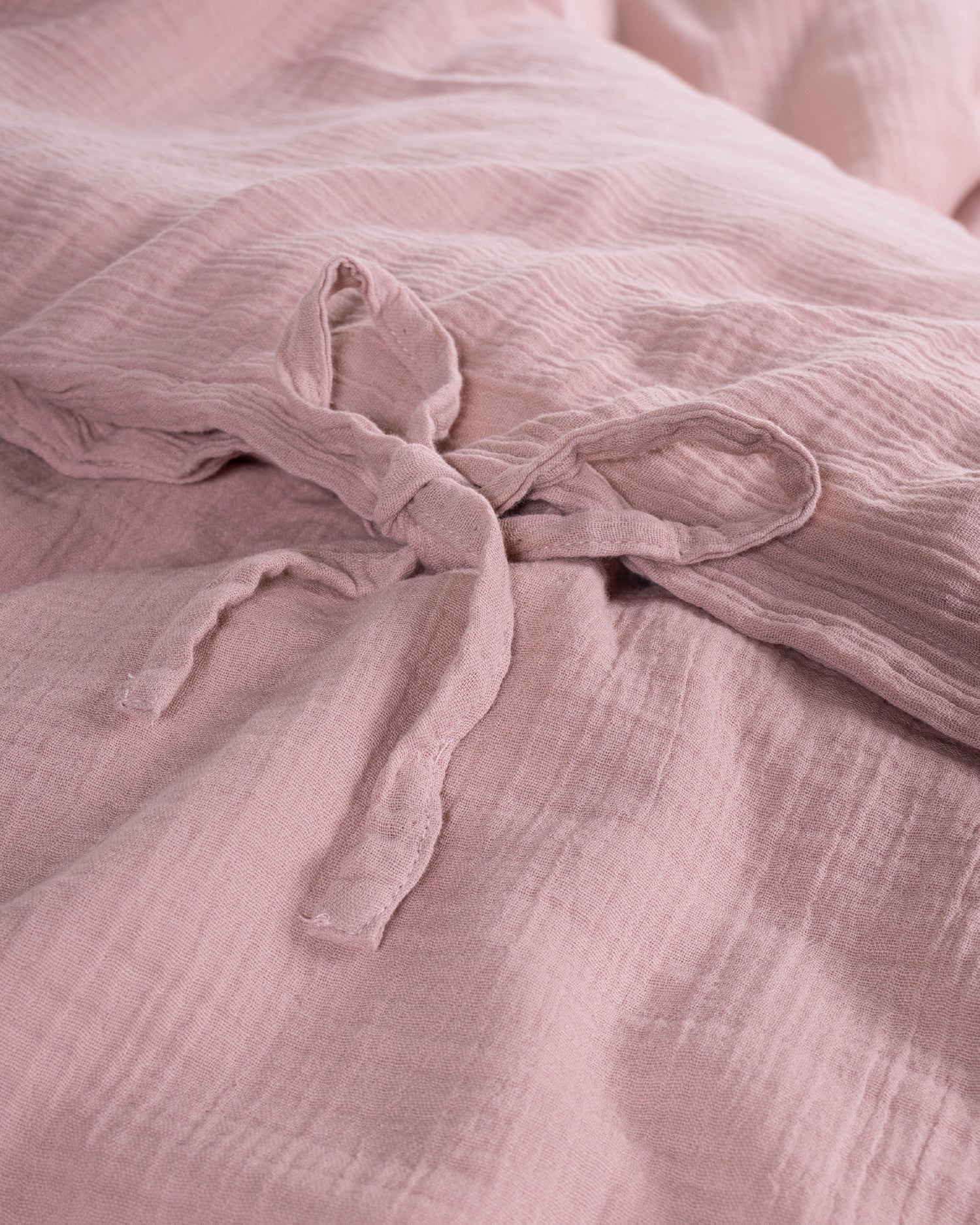 Detail shot of the tie closure on the Esse Old Rose muslin duvet cover showing artisanal fastening – Limasso London