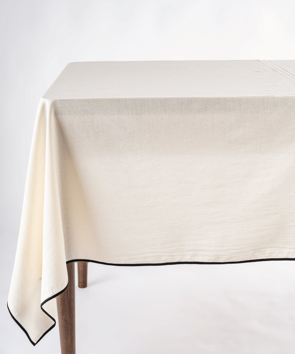 Cream stonewashed 100% cotton tablecloth with embroidered edges on rectangular dining table, soft textured dining table linen for UK homes