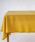 Honey stonewashed 100% cotton tablecloth with embroidered edges on rectangular dining table, soft textured dining table linen for UK homes