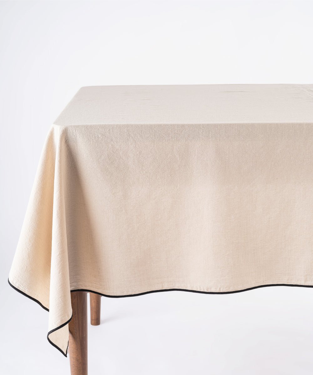 Oxfordtan beige stonewashed 100% cotton tablecloth with embroidered edges on rectangular dining table, soft textured dining table linen for UK homes