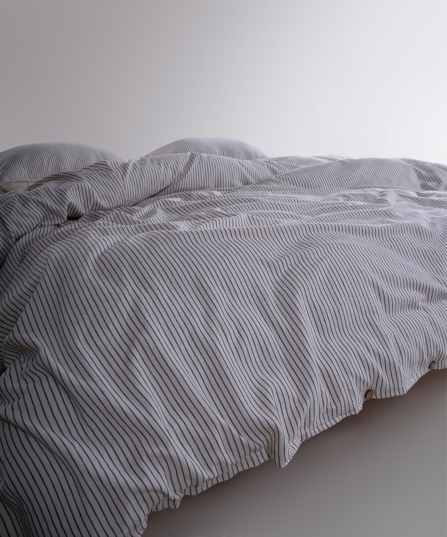 Close-up of 100% cotton garment washed fabric showing natural cream texture with fine black stripes