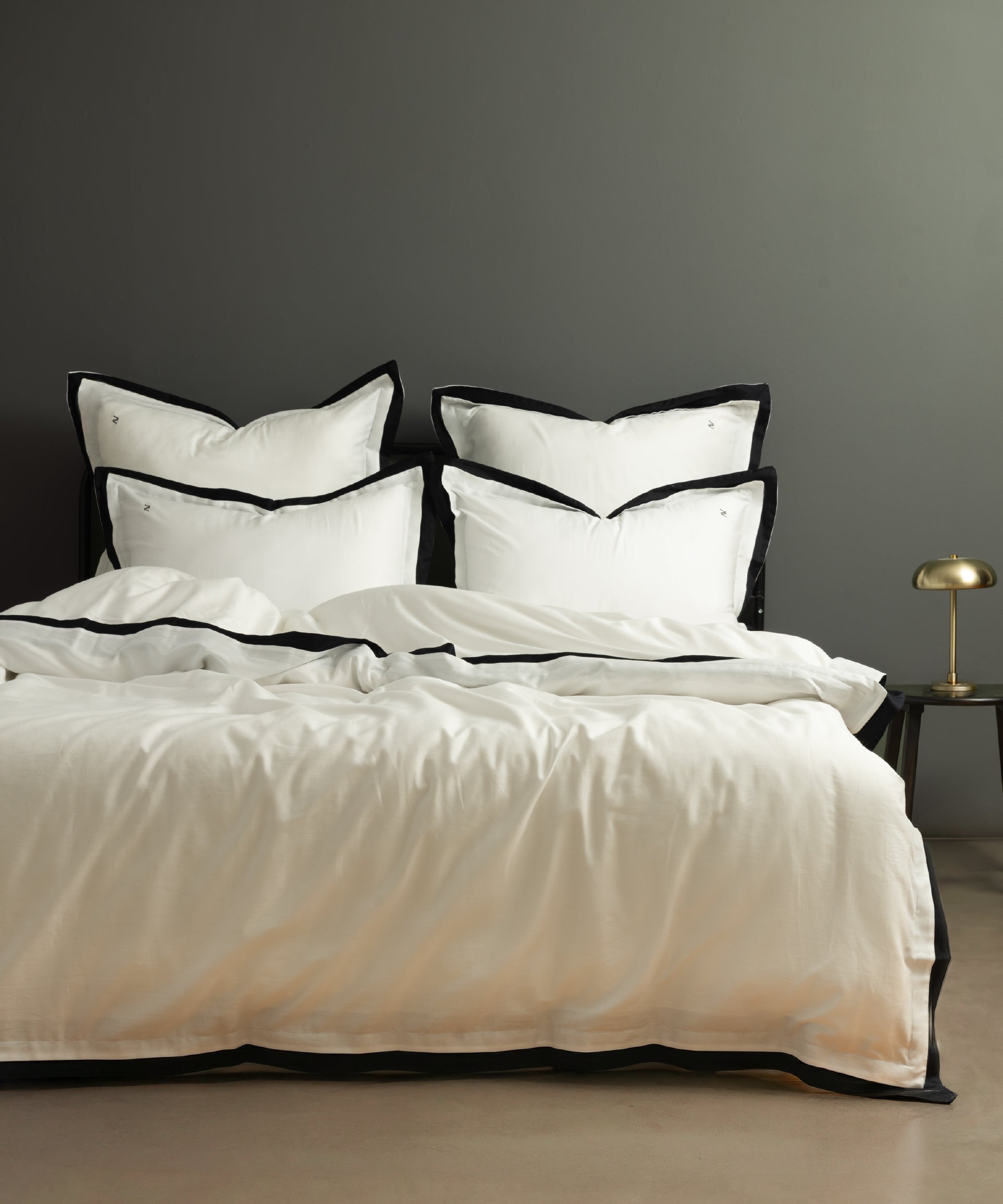 White 100% cotton sateen duvet cover set with black border and Oxford edges styled on luxury hotel style bed