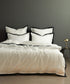 White 100% cotton sateen duvet cover set with black border and Oxford edges styled on luxury hotel style bed