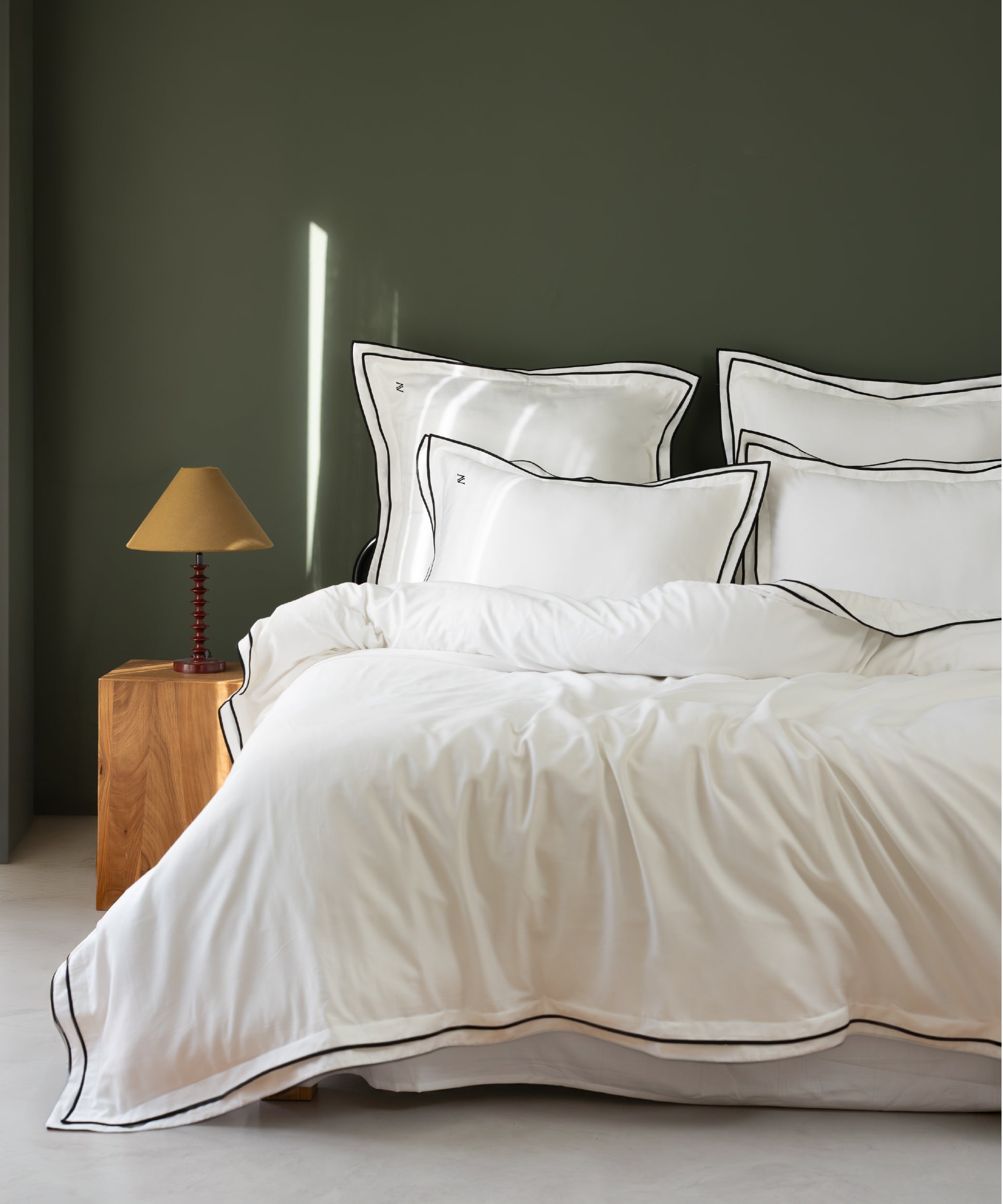White 100% cotton sateen duvet cover set with Oxford edges and fine contrast piping styled on luxury UK bed