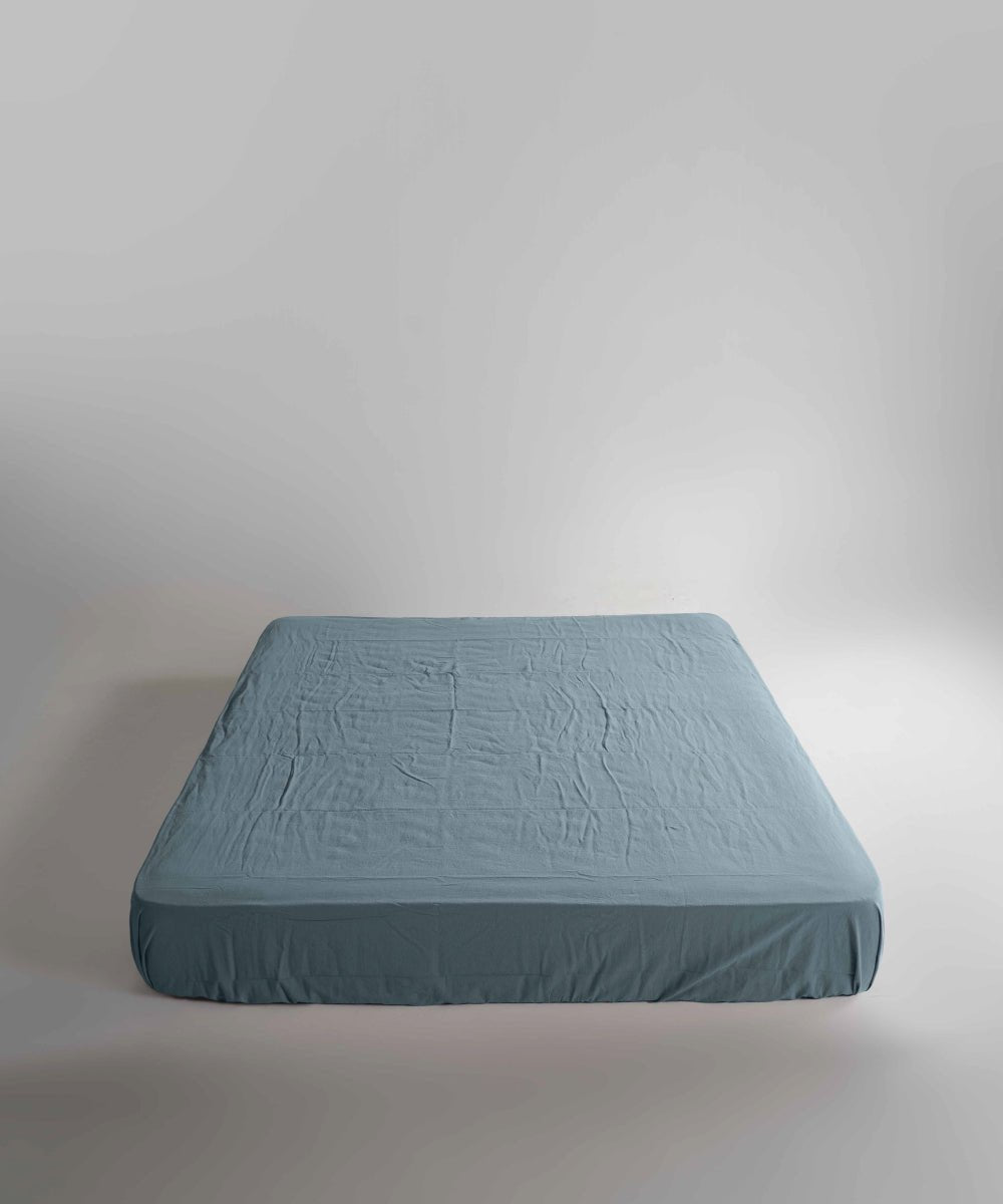 Med Blue fitted sheet made from 100% stonewashed cotton with elasticated corners. Breathable fabric with a relaxed finish, suitable for UK beds with deep mattress options.