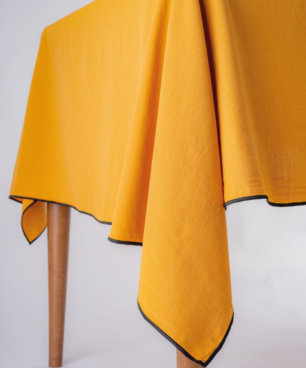 Mustard embroidered cotton tablecloth styled on dining table with plates and decor, rectangular kitchen table cover UK