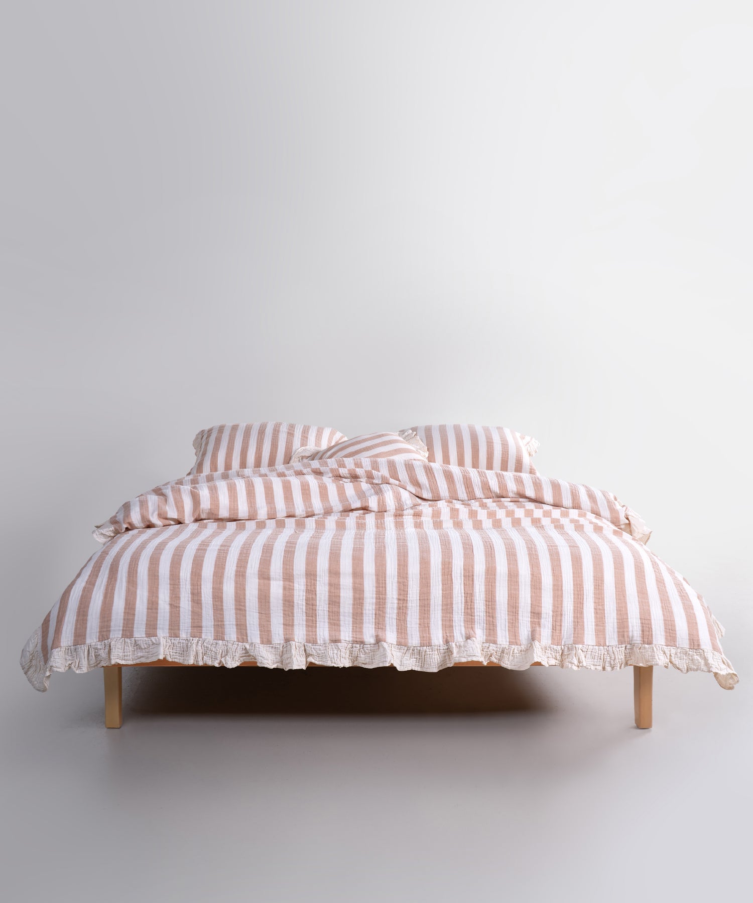 Mustard striped cotton muslin duvet cover set displayed on bed, breathable garment washed bedding with natural cream base