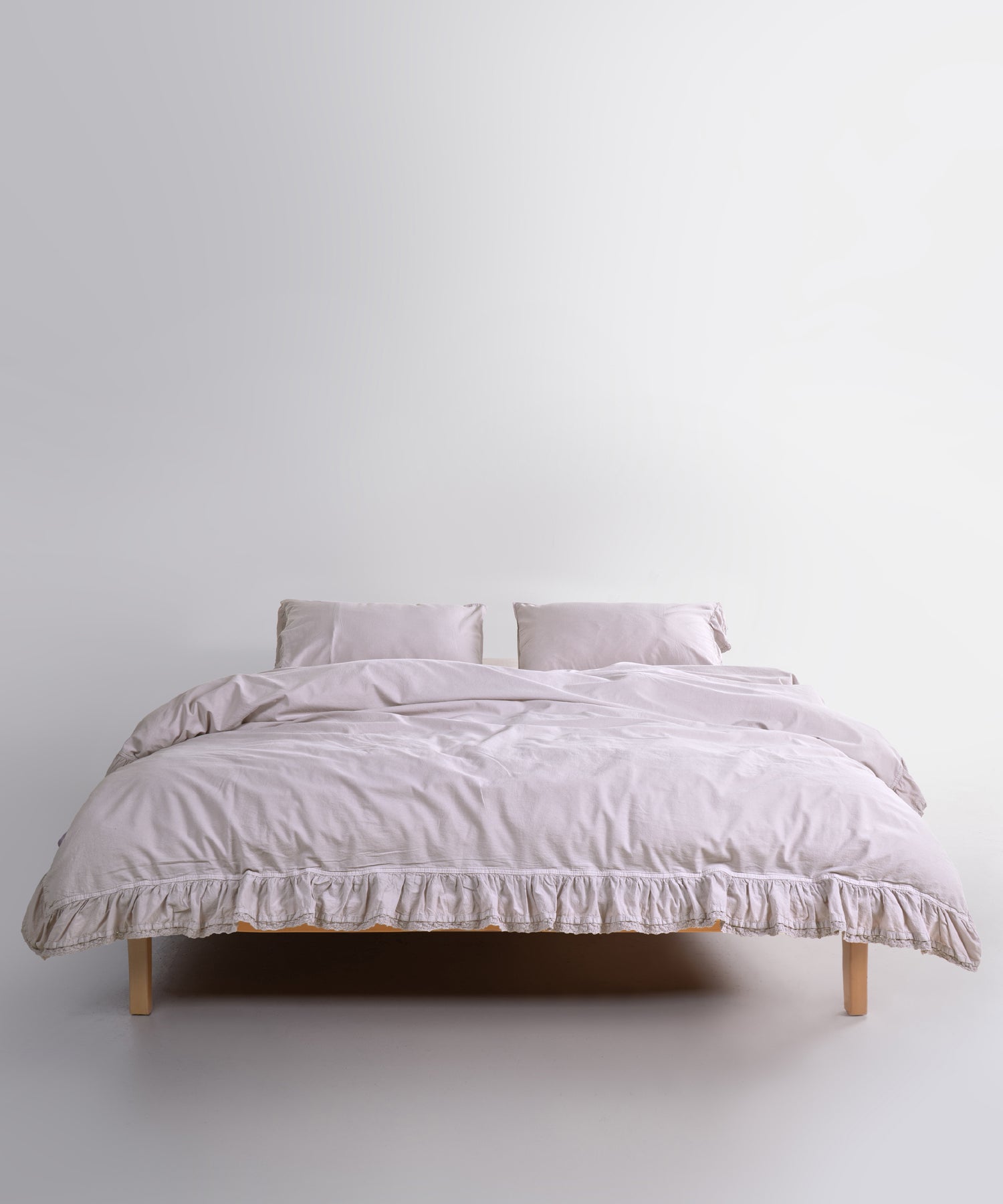 Close up of Sicilia Natura Cream stonewashed cotton duvet cover with elegant ruffle lace trim detail