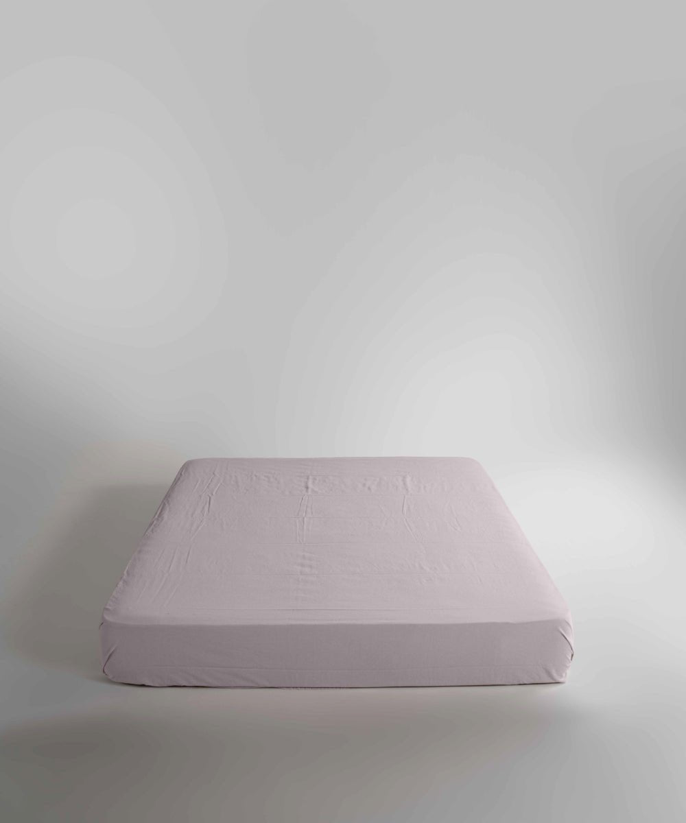 Minimal bedroom styled with a natural cream stonewashed cotton fitted sheet, offering a relaxed look, breathable comfort and a smooth, snug fit for modern UK homes.