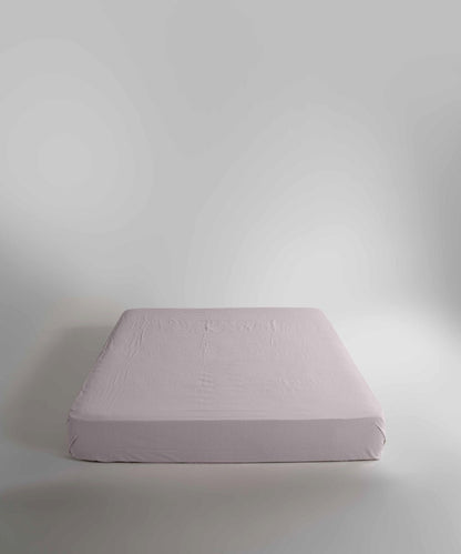 Minimal bedroom styled with a natural cream stonewashed cotton fitted sheet, offering a relaxed look, breathable comfort and a smooth, snug fit for modern UK homes.
