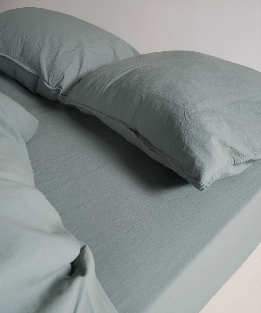 Natural Green pillowcases styled on bed for a calm, modern bedroom look. Stonewashed cotton texture adds softness and a relaxed, premium feel.