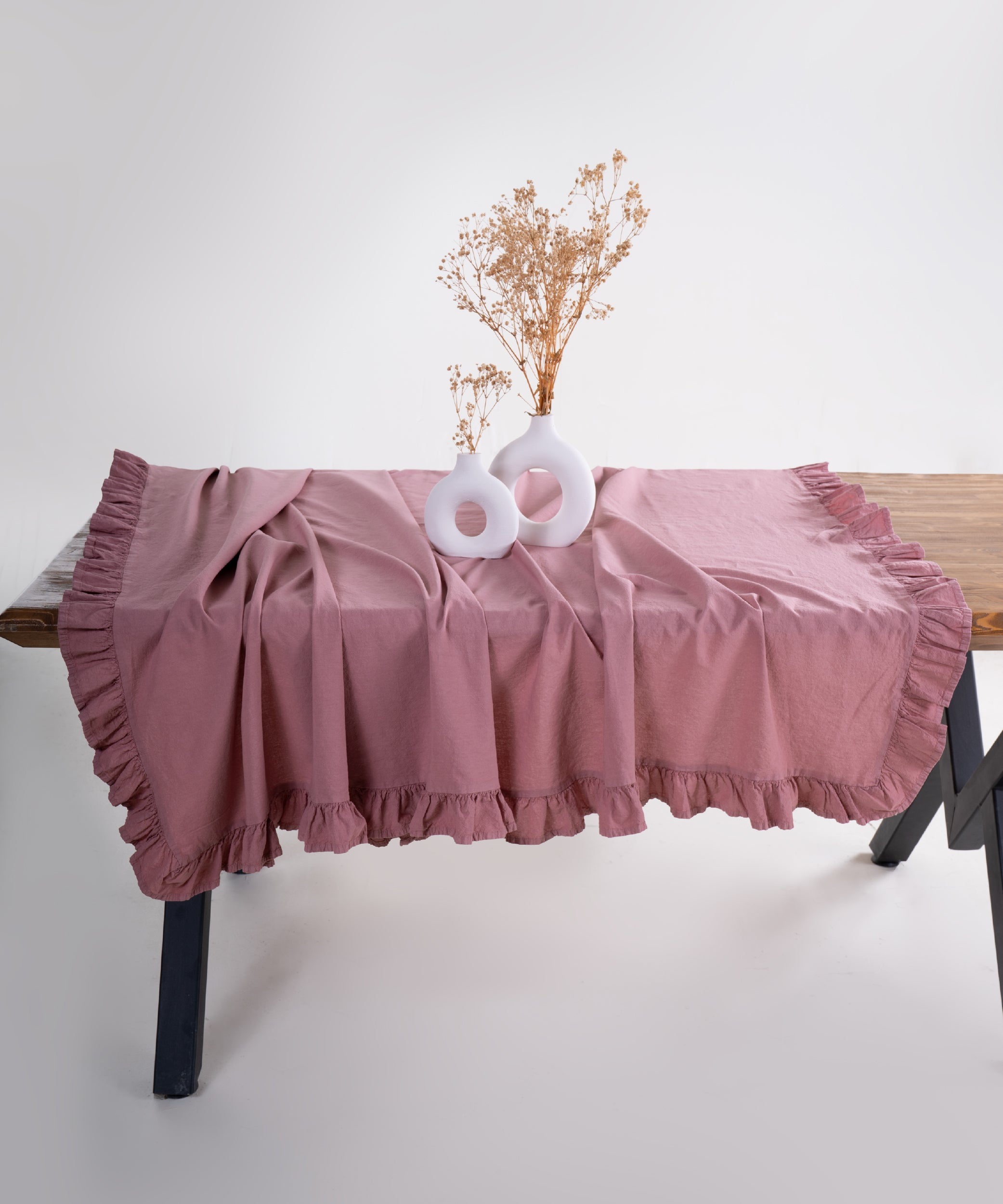 Old Rose pink embroidered ruffle edge cotton tablecloth styled on dining table with plates and decor, UK kitchen table cover