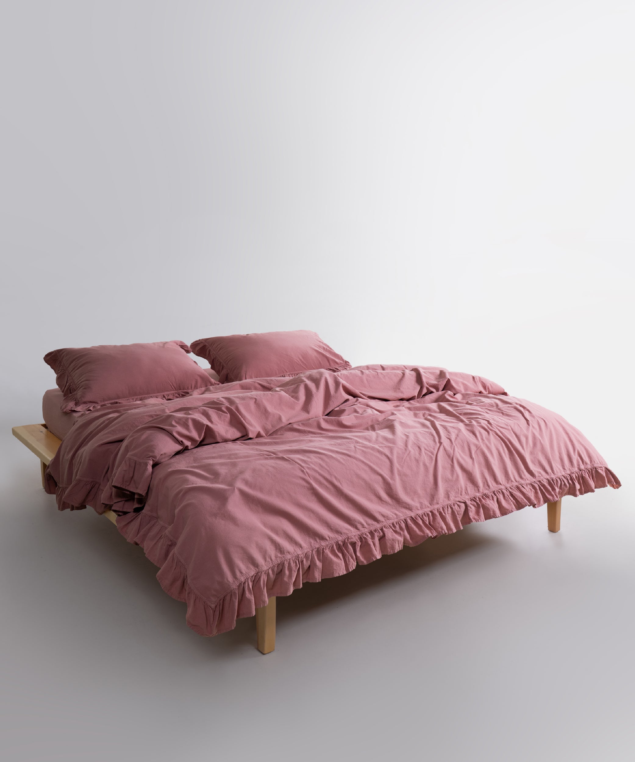 Close-up of stonewashed 100% cotton duvet cover in Old Rose showing soft texture and ruffle trim