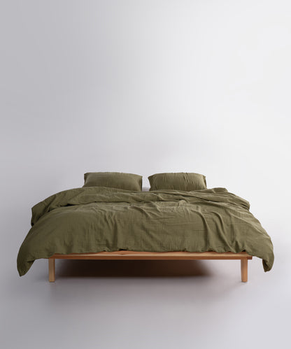 Close-up of Cloud Olive muslin gauze duvet cover and pillowcases showing soft crinkle texture – Limasso London