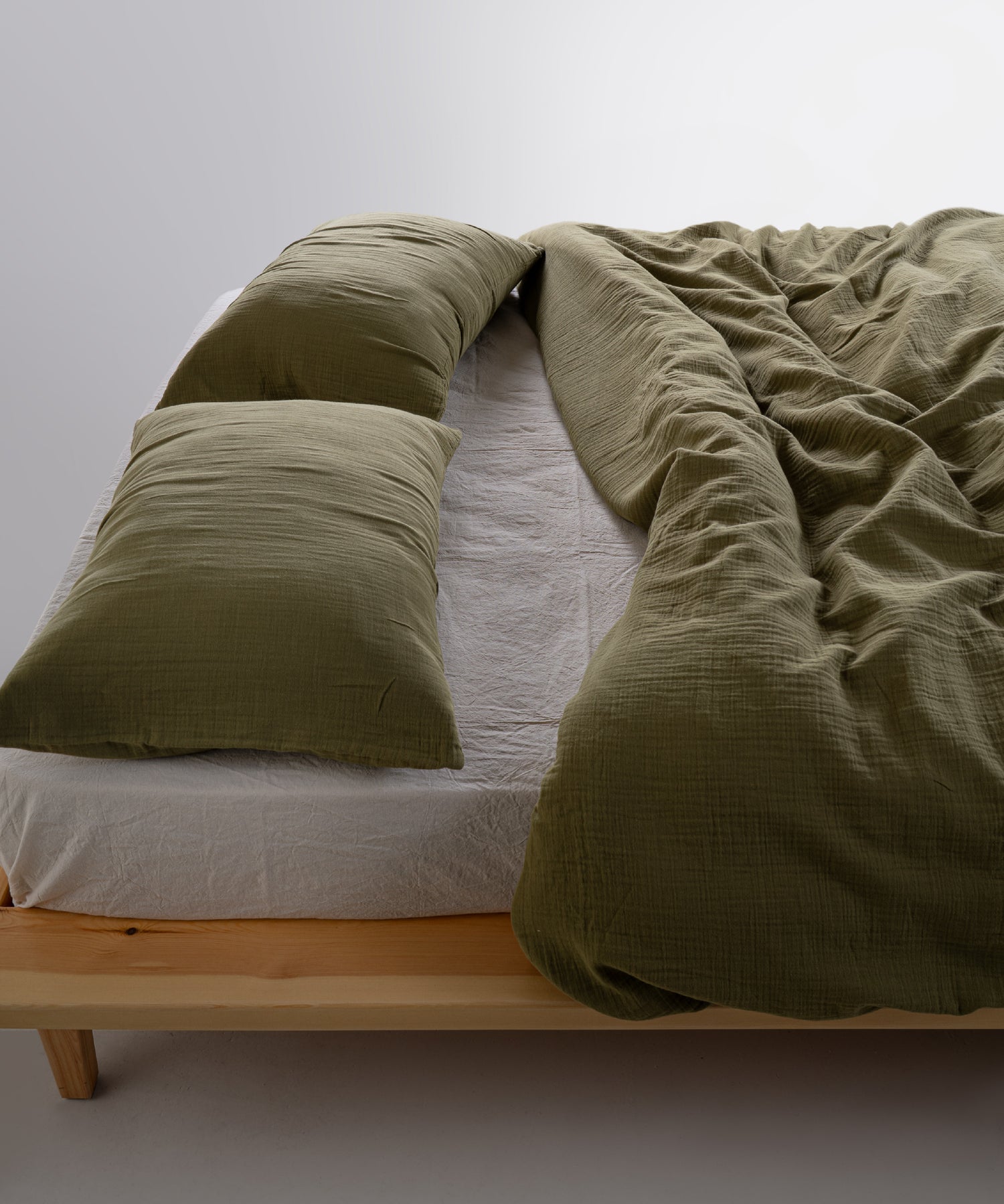 Cloud Olive muslin gauze duvet cover set angled view showing crinkle texture and matching pillowcases – Limasso London