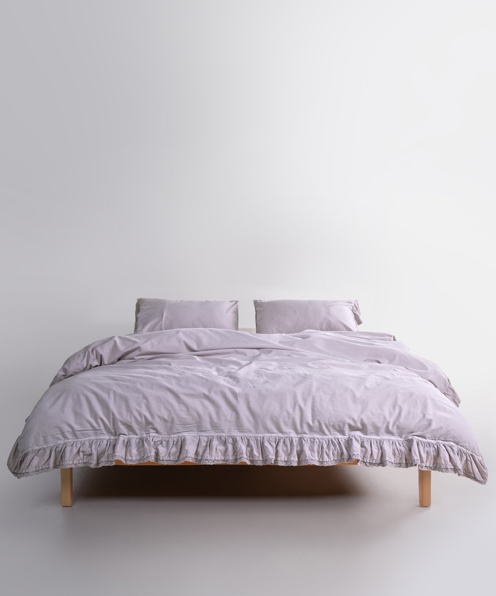 Close up of Sicilia Opal Grey stonewashed cotton duvet cover with elegant ruffle lace trim detail
