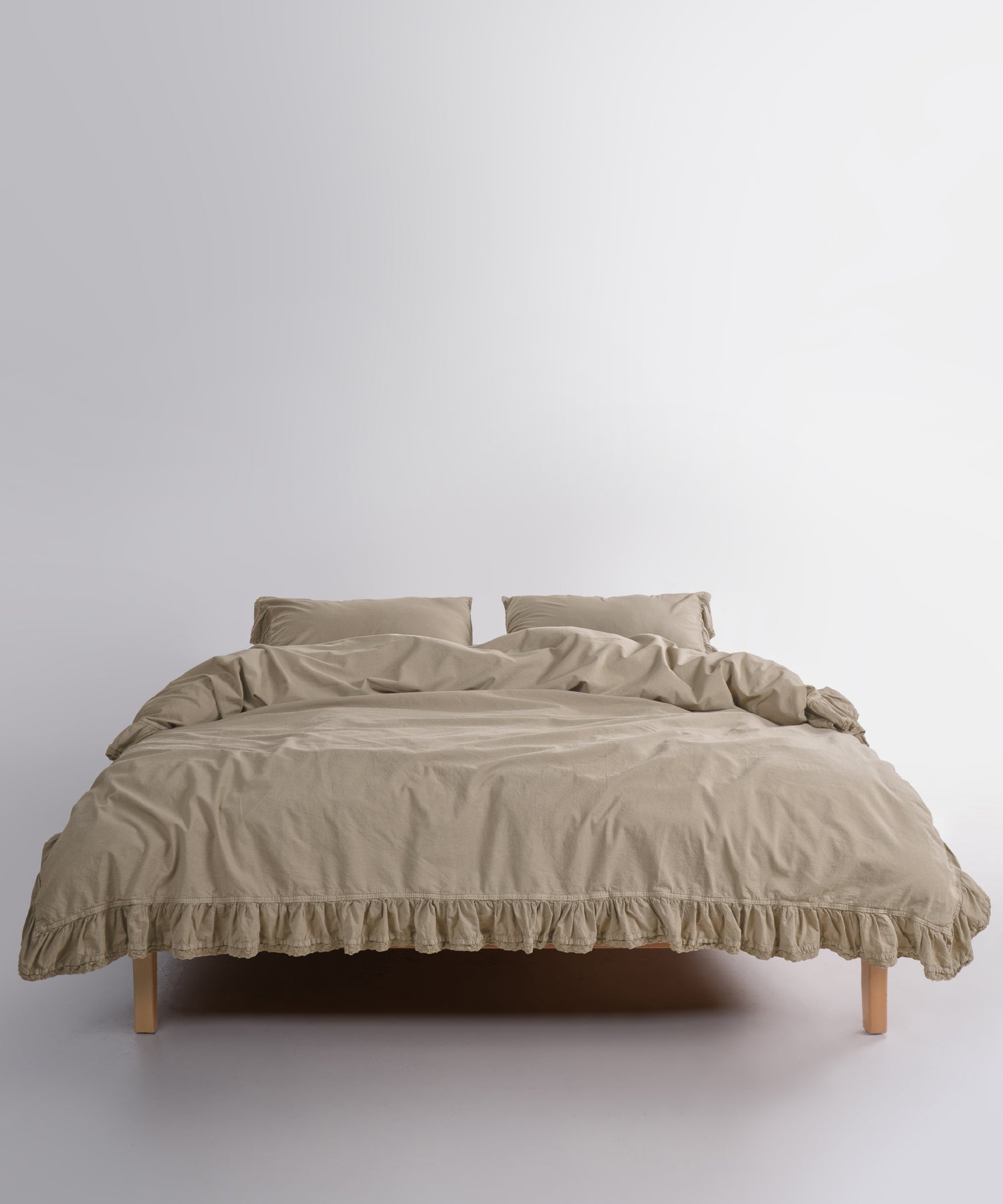 Close up of Sicilia Oxford Tan stonewashed cotton duvet cover with elegant ruffle lace trim detail