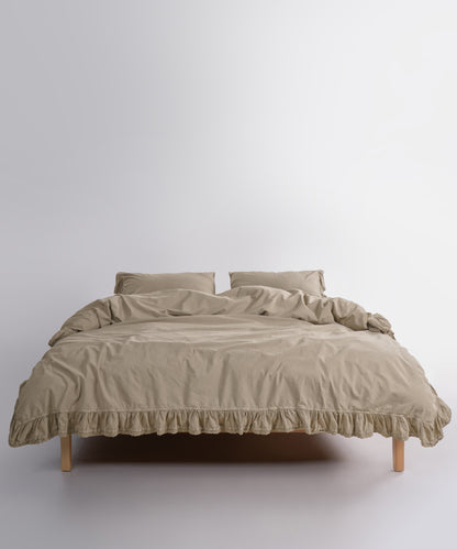 Close up of Sicilia Oxford Tan stonewashed cotton duvet cover with elegant ruffle lace trim detail