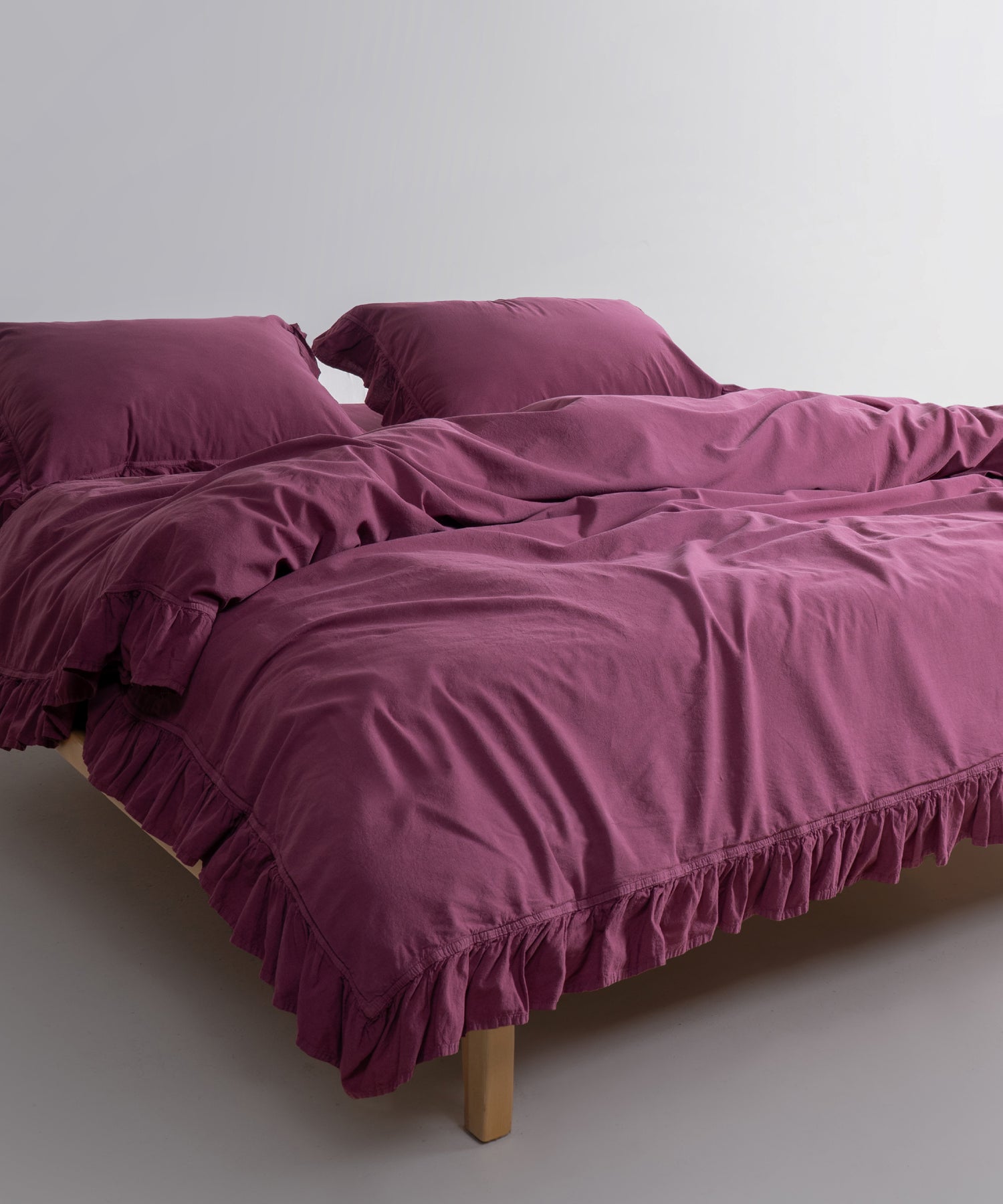 Close-up of stonewashed 100% natural cotton fabric in Raspberry colour showing soft texture and breathable weave for year-round comfort.